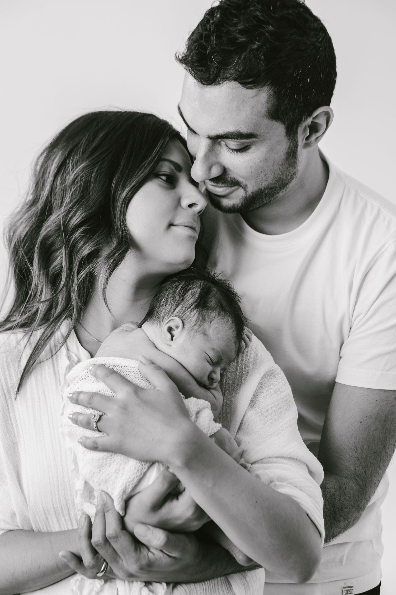 Intimate family portrait in black and white with newborn baby.