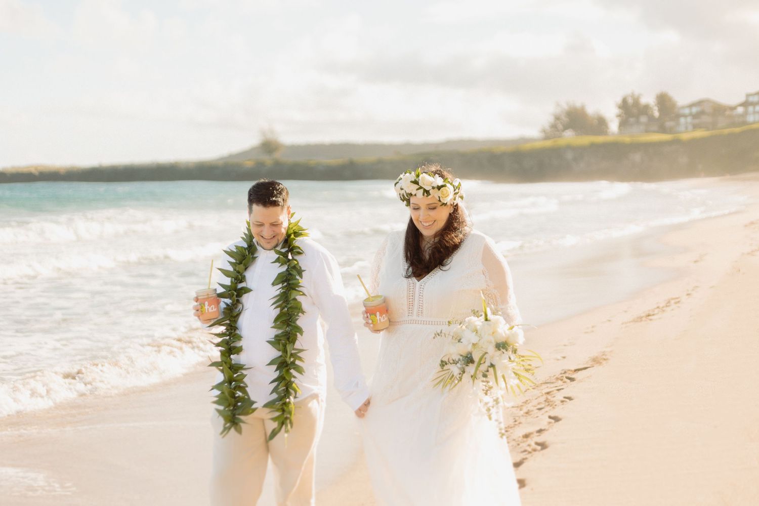 couple walks the beach at golden hour during their hawaiian elopement