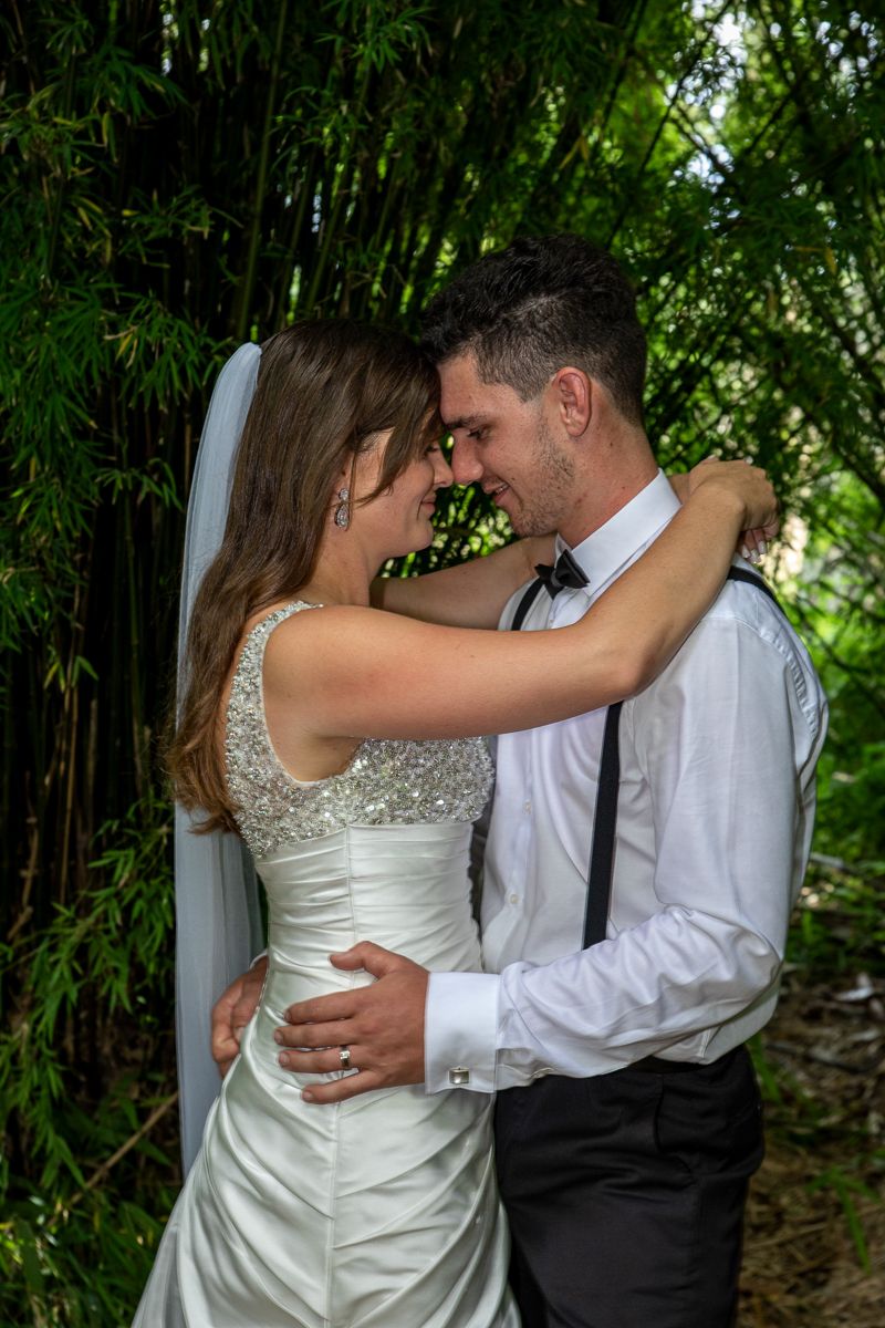 Groom and Bride each other smiling in garden