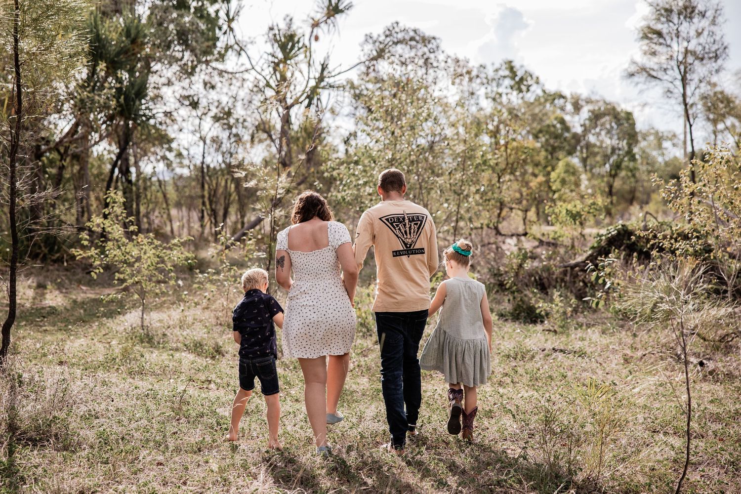 A family walks together through bushland on a nature trail.