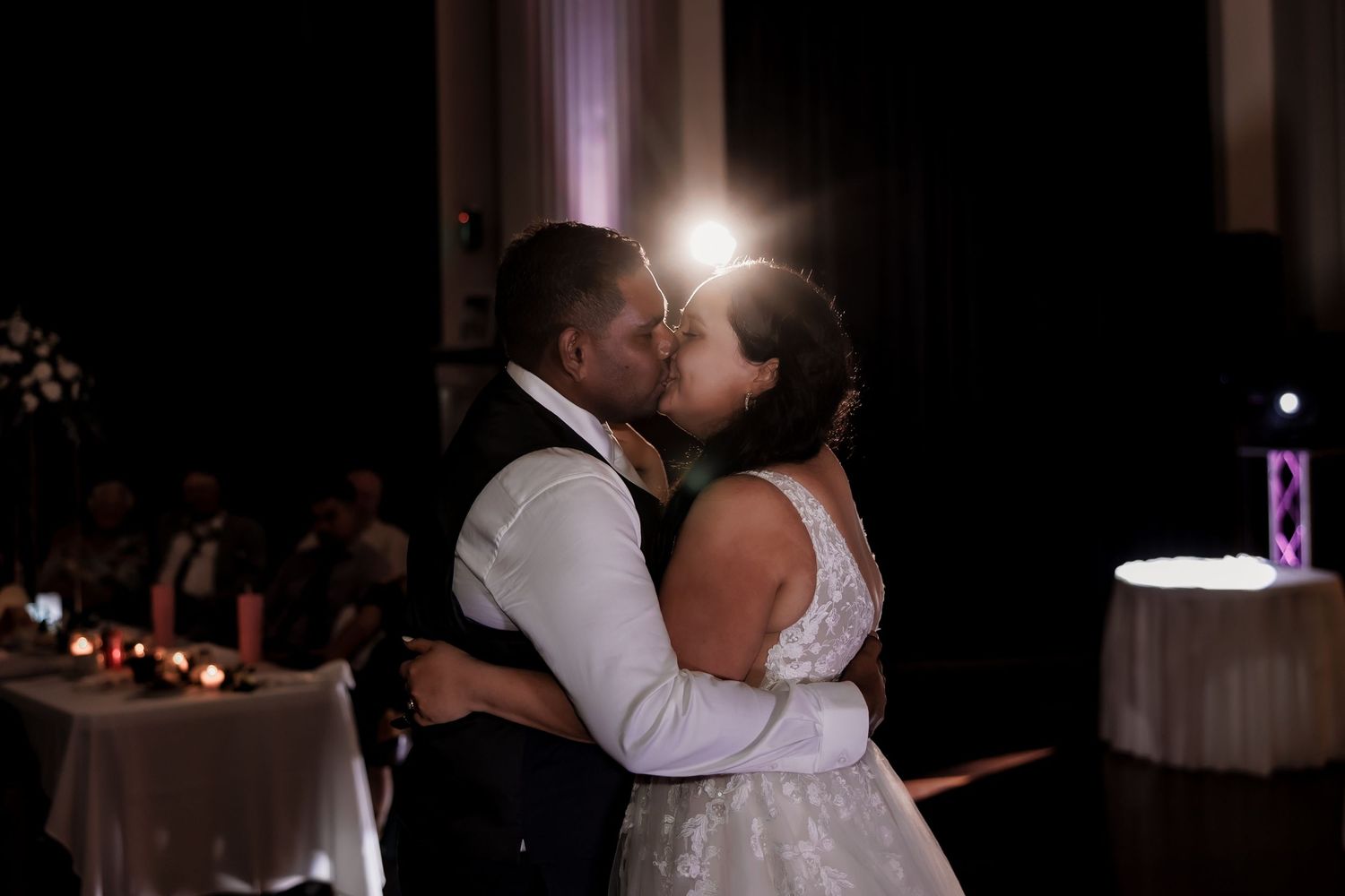 An intimate first dance moment at a wedding reception with dramatic lighting and romantic ambiance.