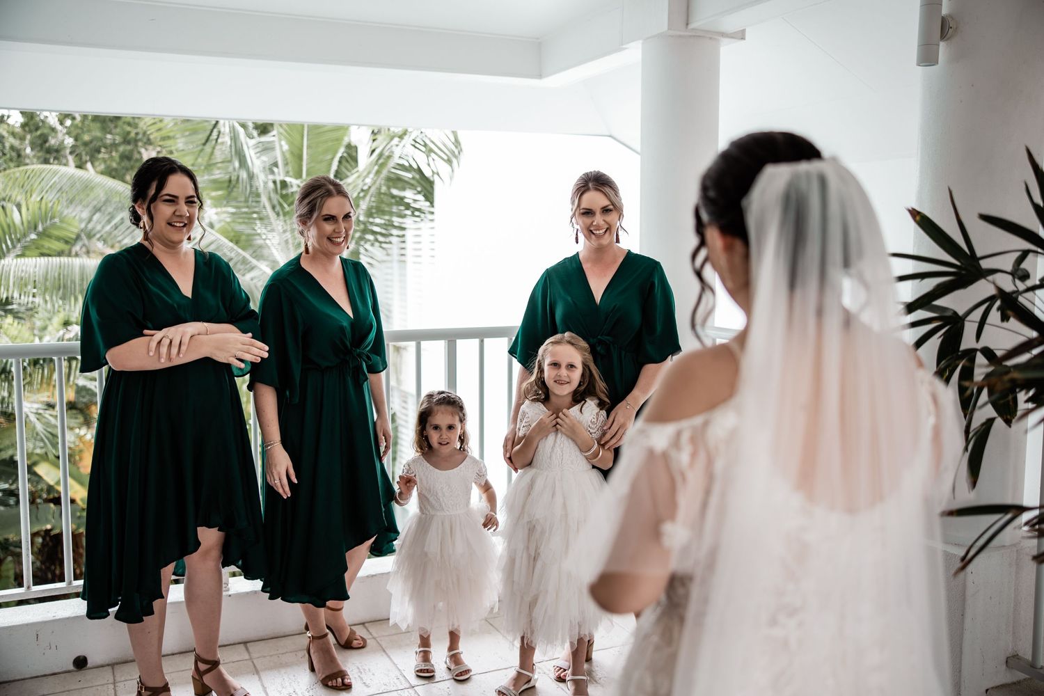 Bridesmaids and flower girl share excited reactions with the bride before the ceremony.