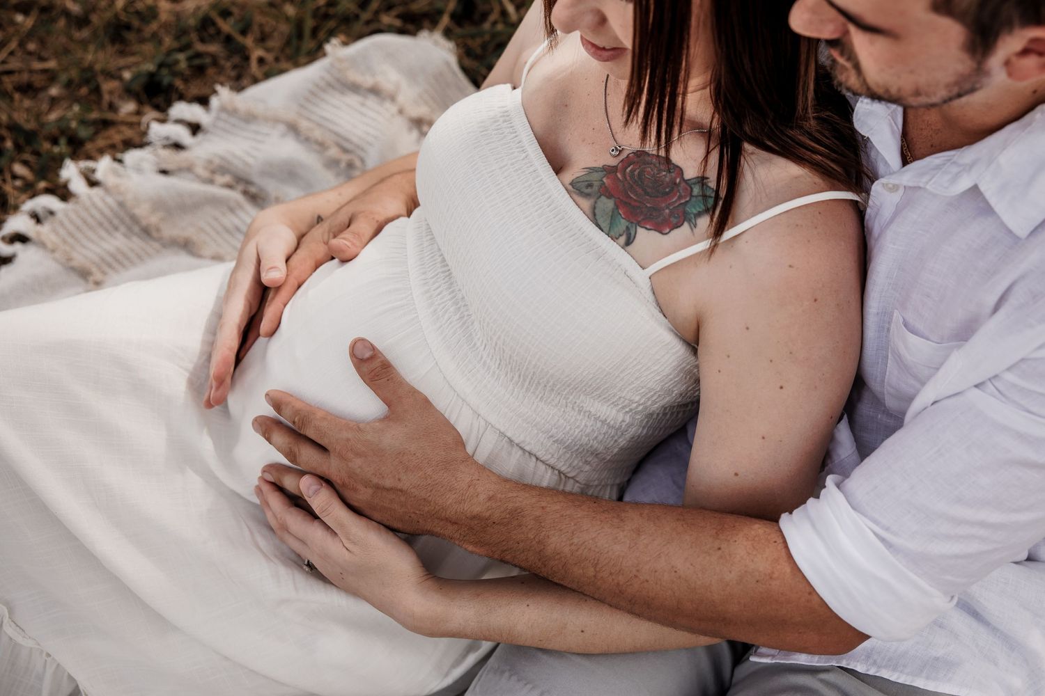 A tender moment captured between a couple in white and casual attire.