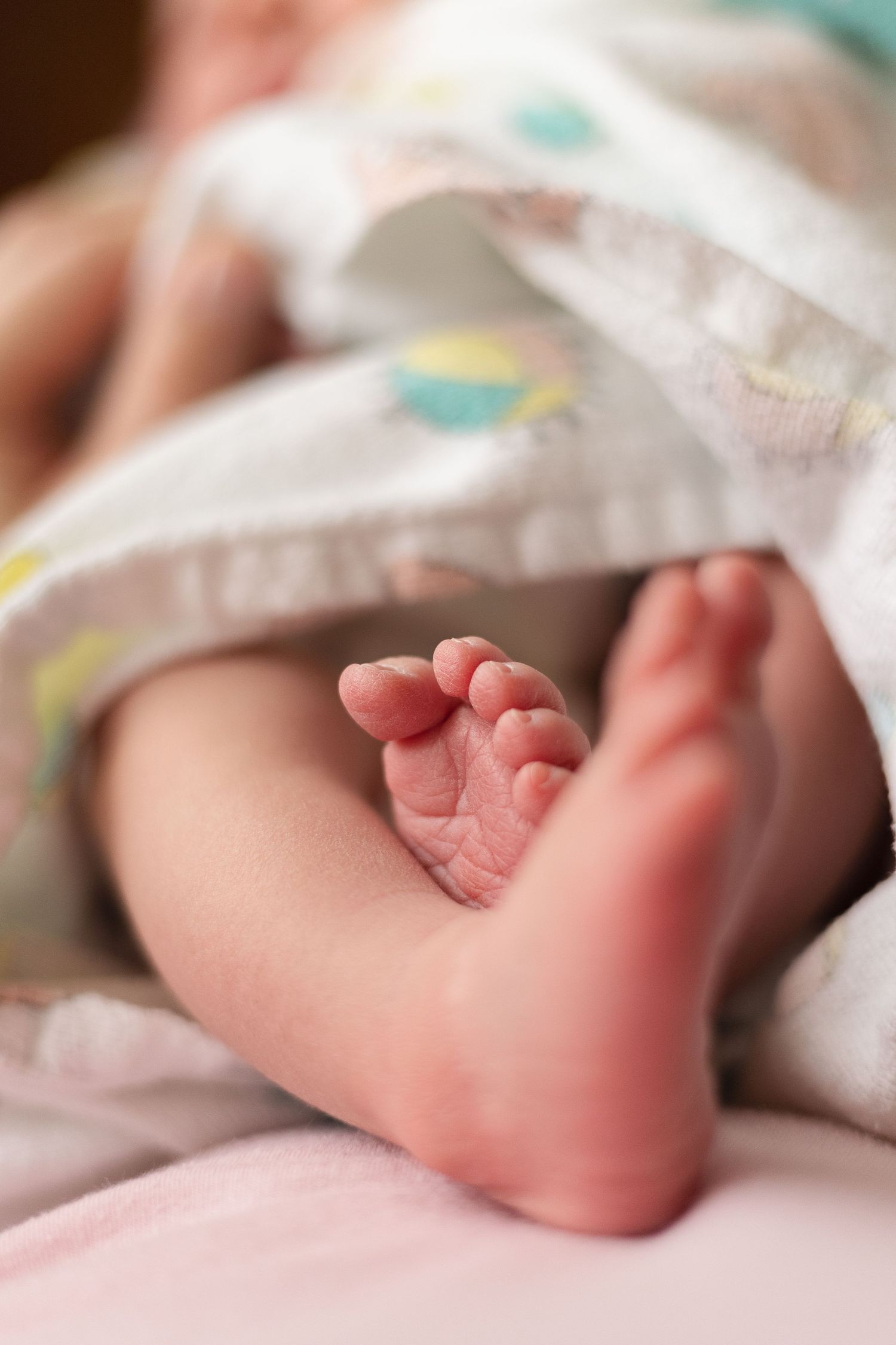 Close up shot of newborn feet on moms belly in a hospital room in Salina Kansas