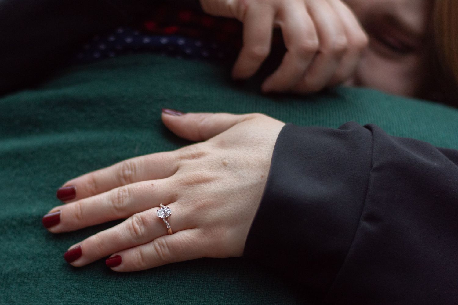 A newly engaged couple, close up on her hand.