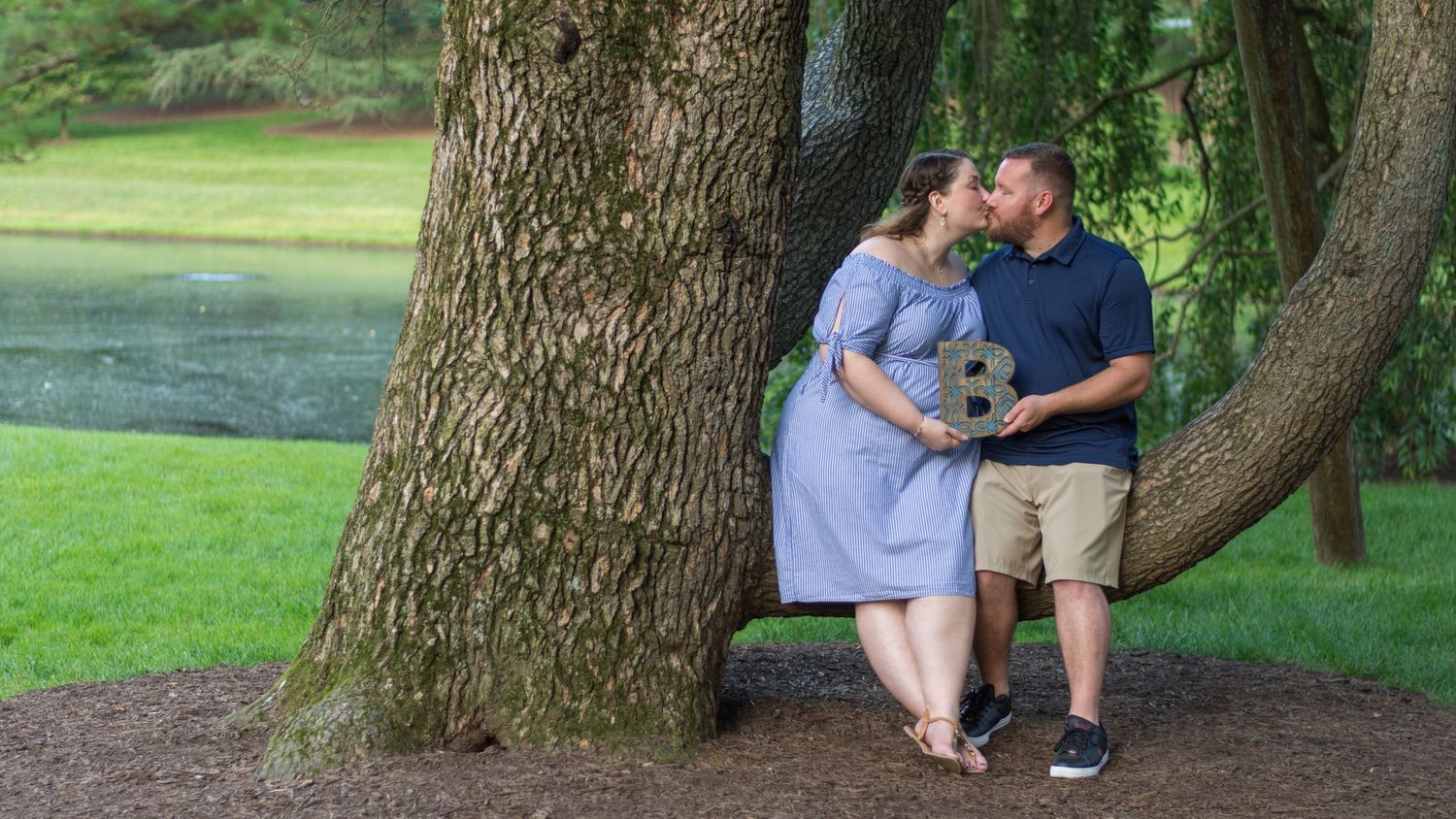 A newly engaged couple kissing.