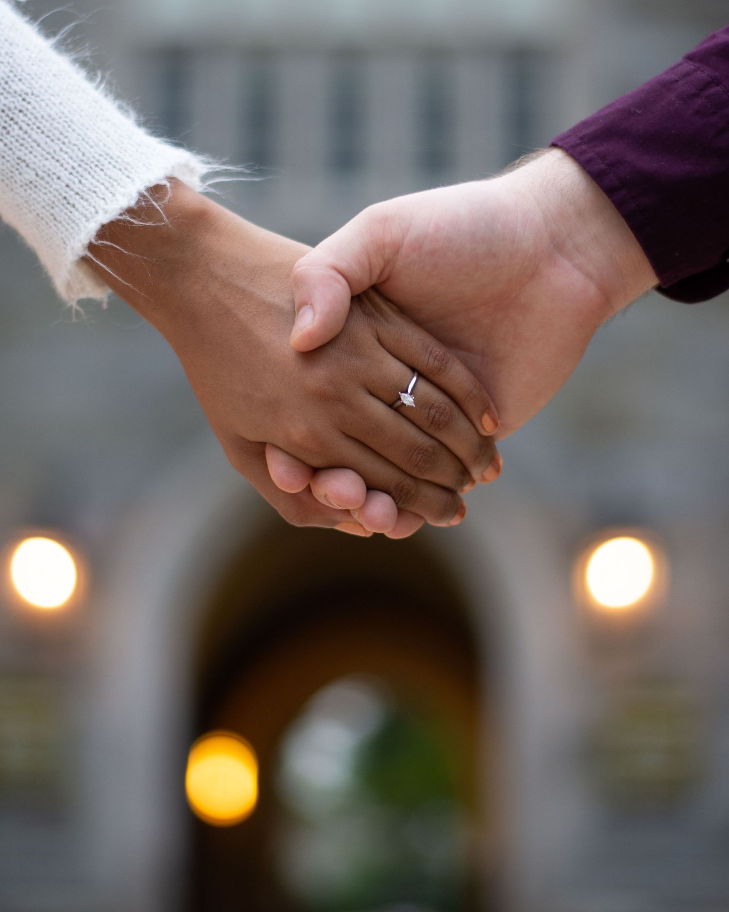 A newly engaged couple holding hands.