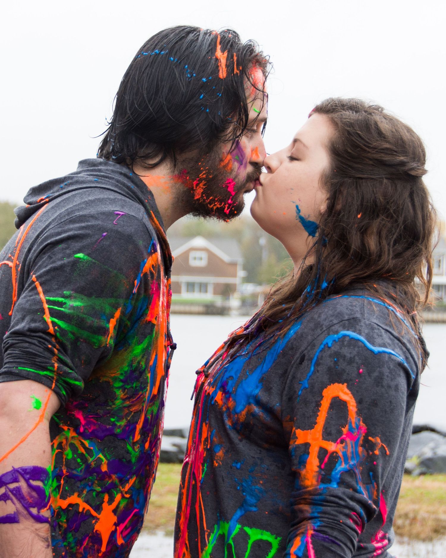 A newly engaged couple kissing post paint-slinging fight.