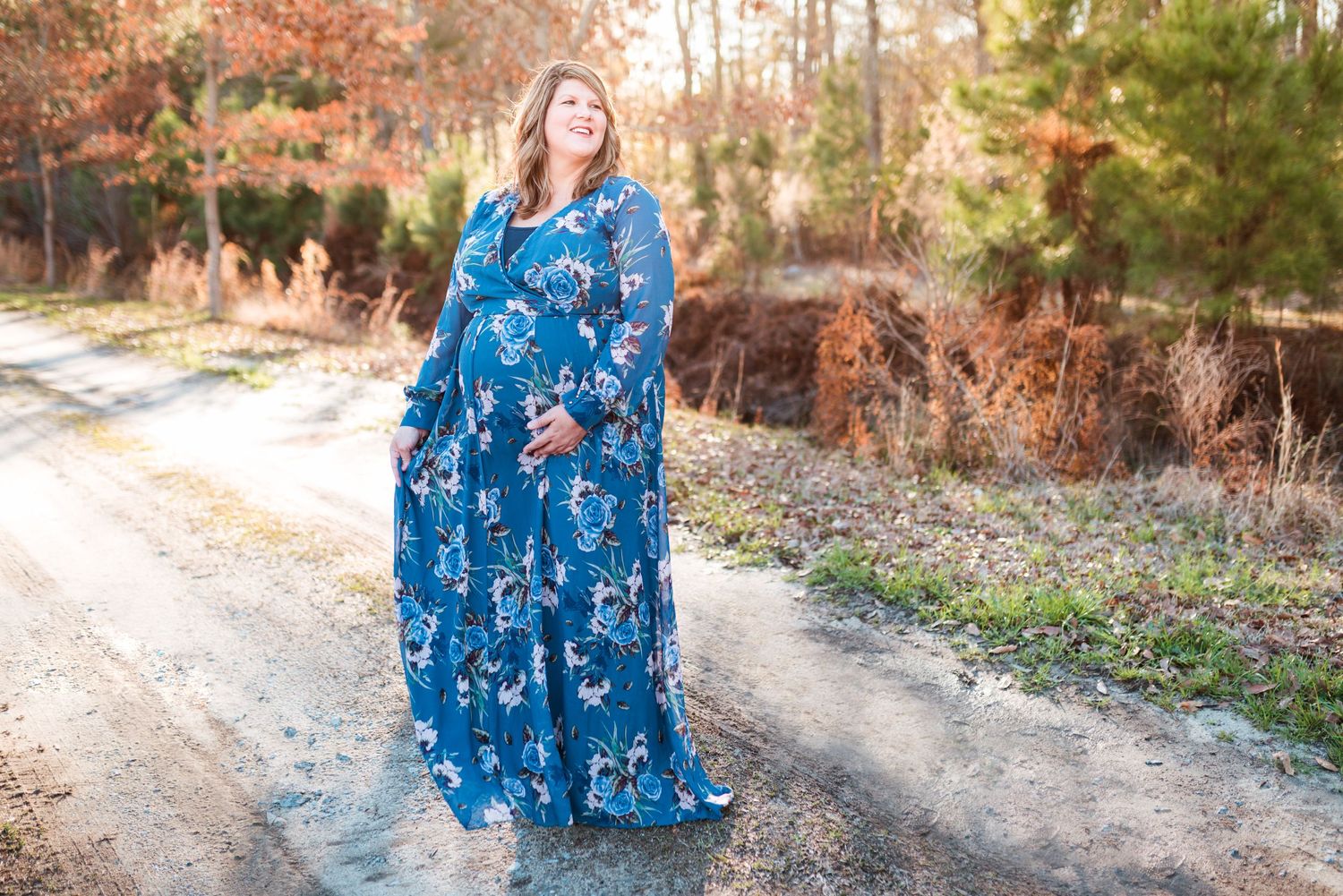 Outdoor autumn photography session featuring blue floral dress against fall foliage.