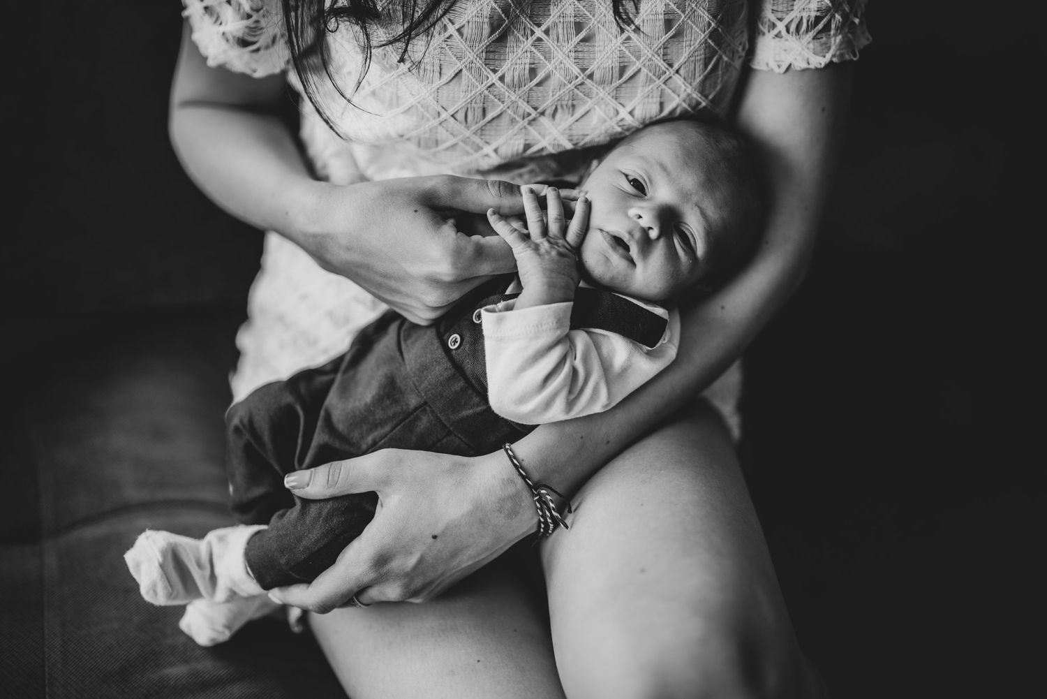 Black and white intimate portrait of a caregiver holding a baby.