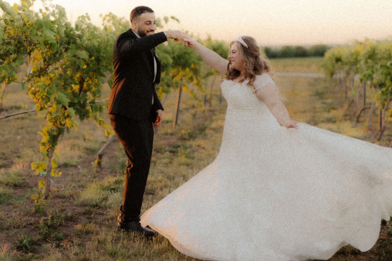 Bride and groom at Capitol View Winery wedding, embracing at sunset with a golden vineyard backdrop, capturing a romantic moment