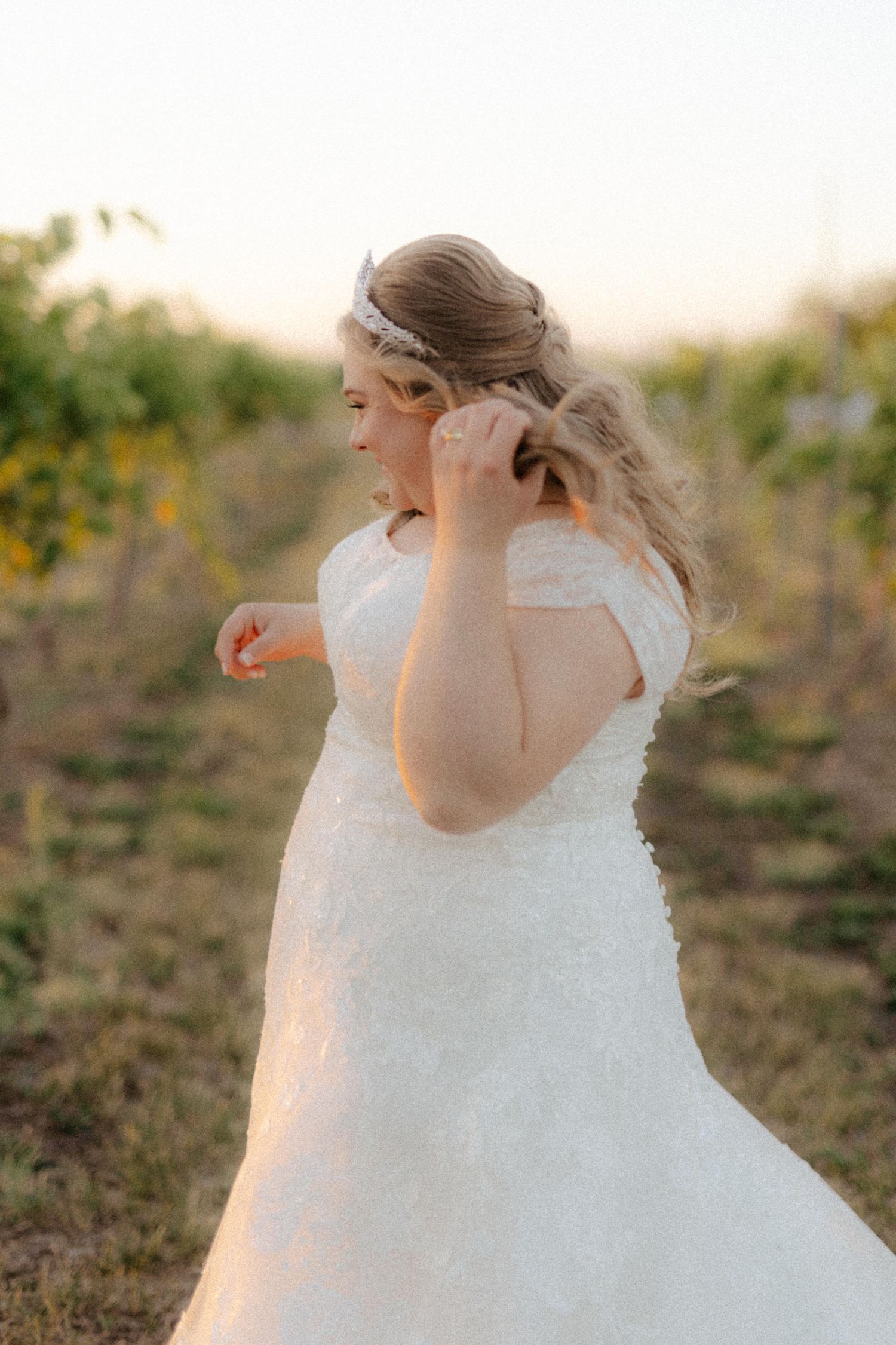 Bride at Capitol View Winery wedding, embracing at sunset with a golden vineyard backdrop, capturing a romantic moment
