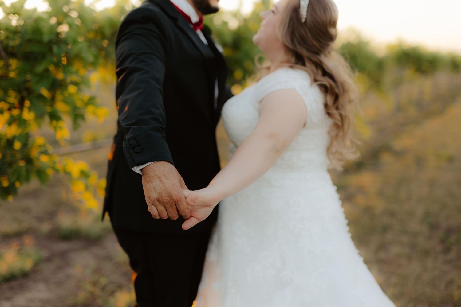 Bride and groom at Capitol View Winery wedding, embracing at sunset with a golden vineyard backdrop, capturing a romantic moment