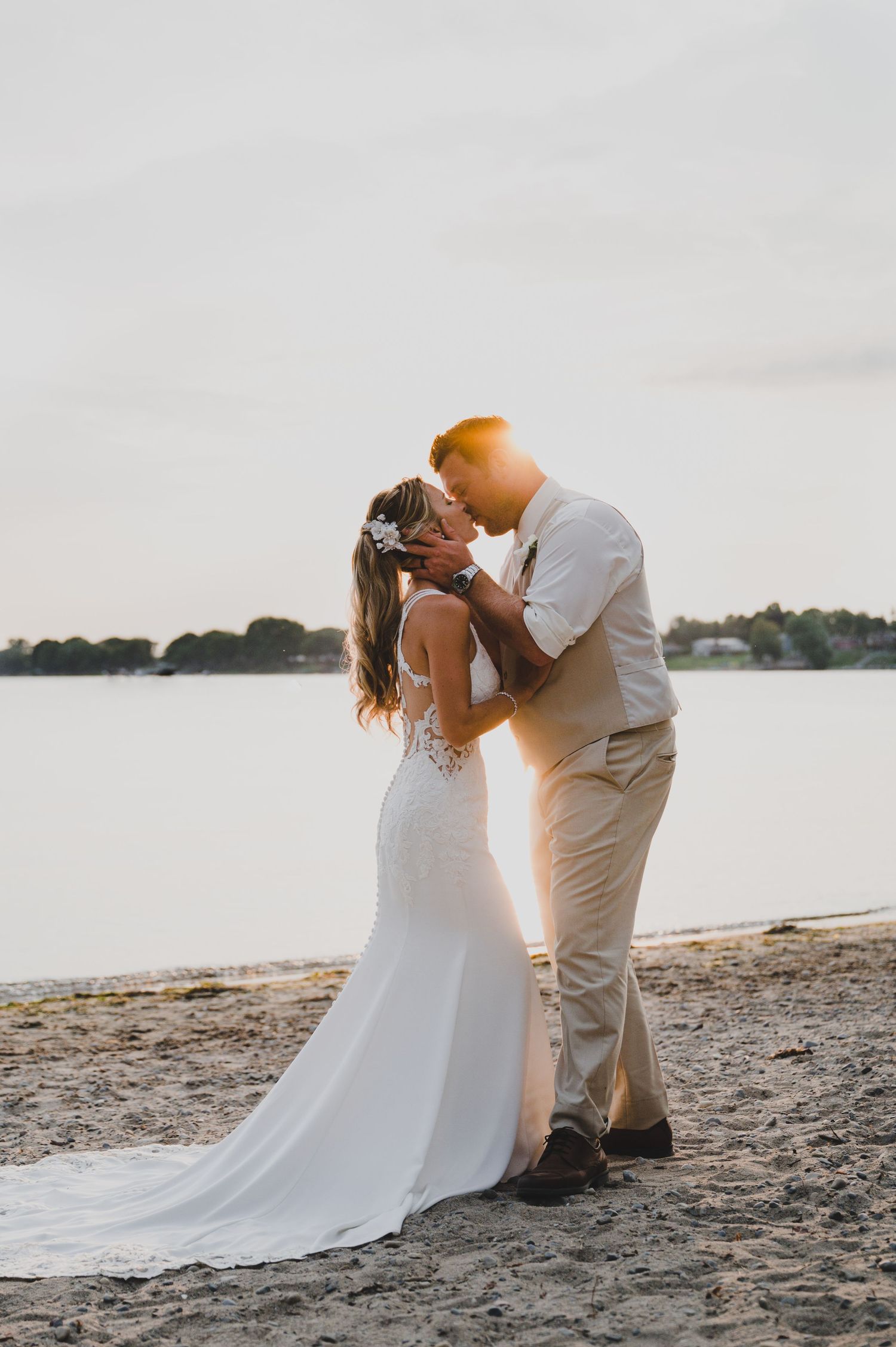 Sunset beach wedding portrait with golden light illuminating an intimate moment.