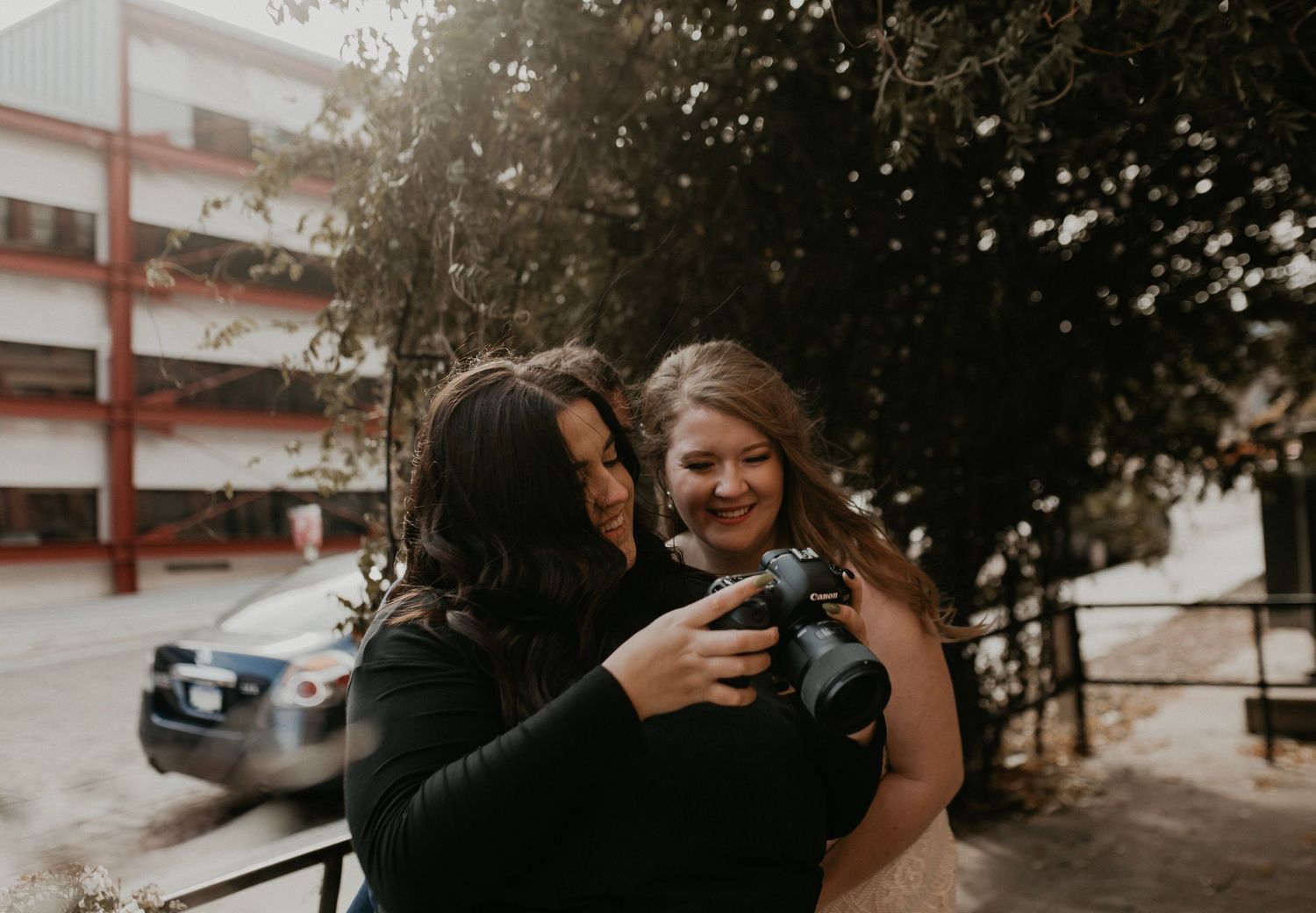Candid moment of joyful laughter during wedding celebration outdoors.