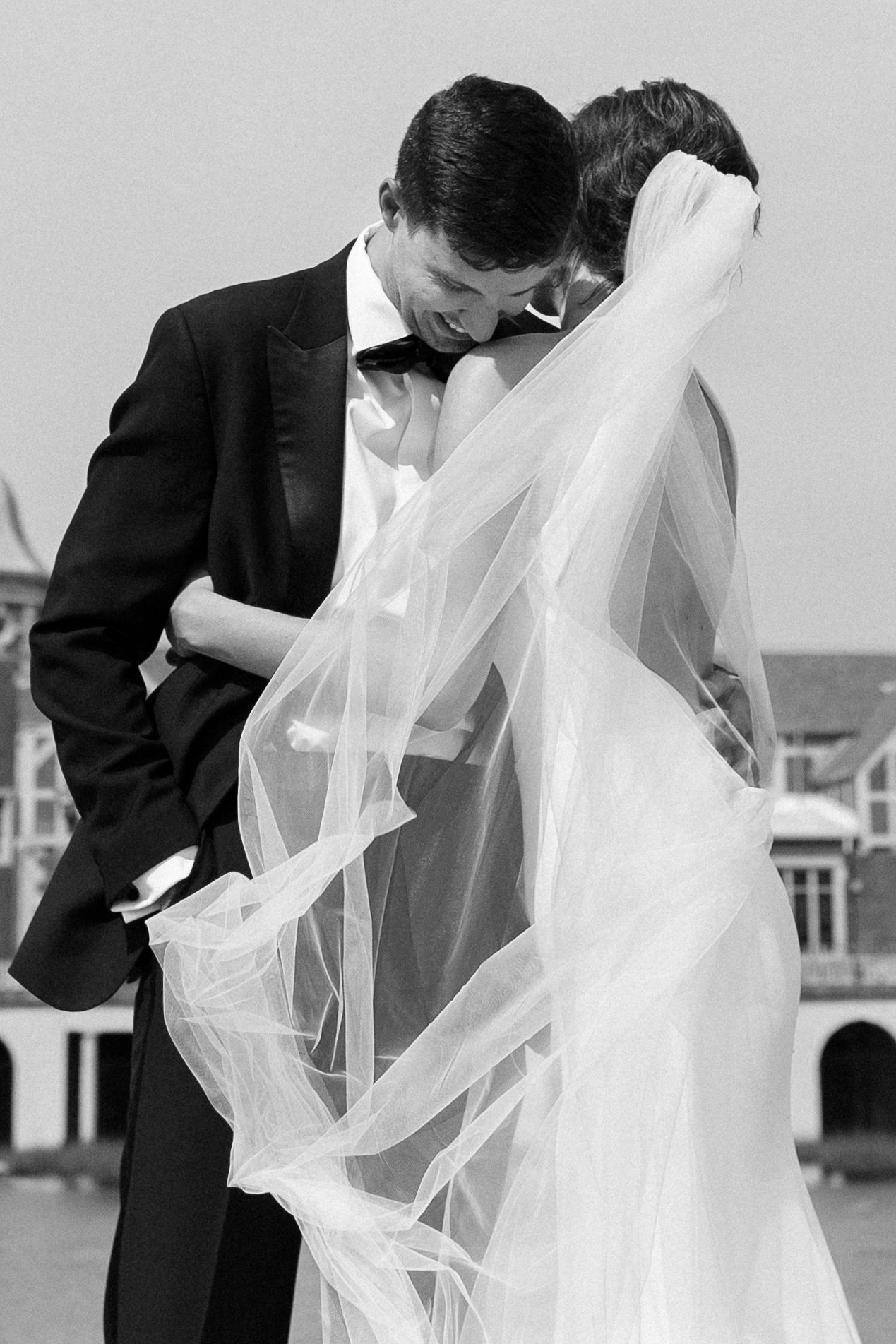 black and white photo of bride and groom in stylish attire embrace in humboldt park, chicago