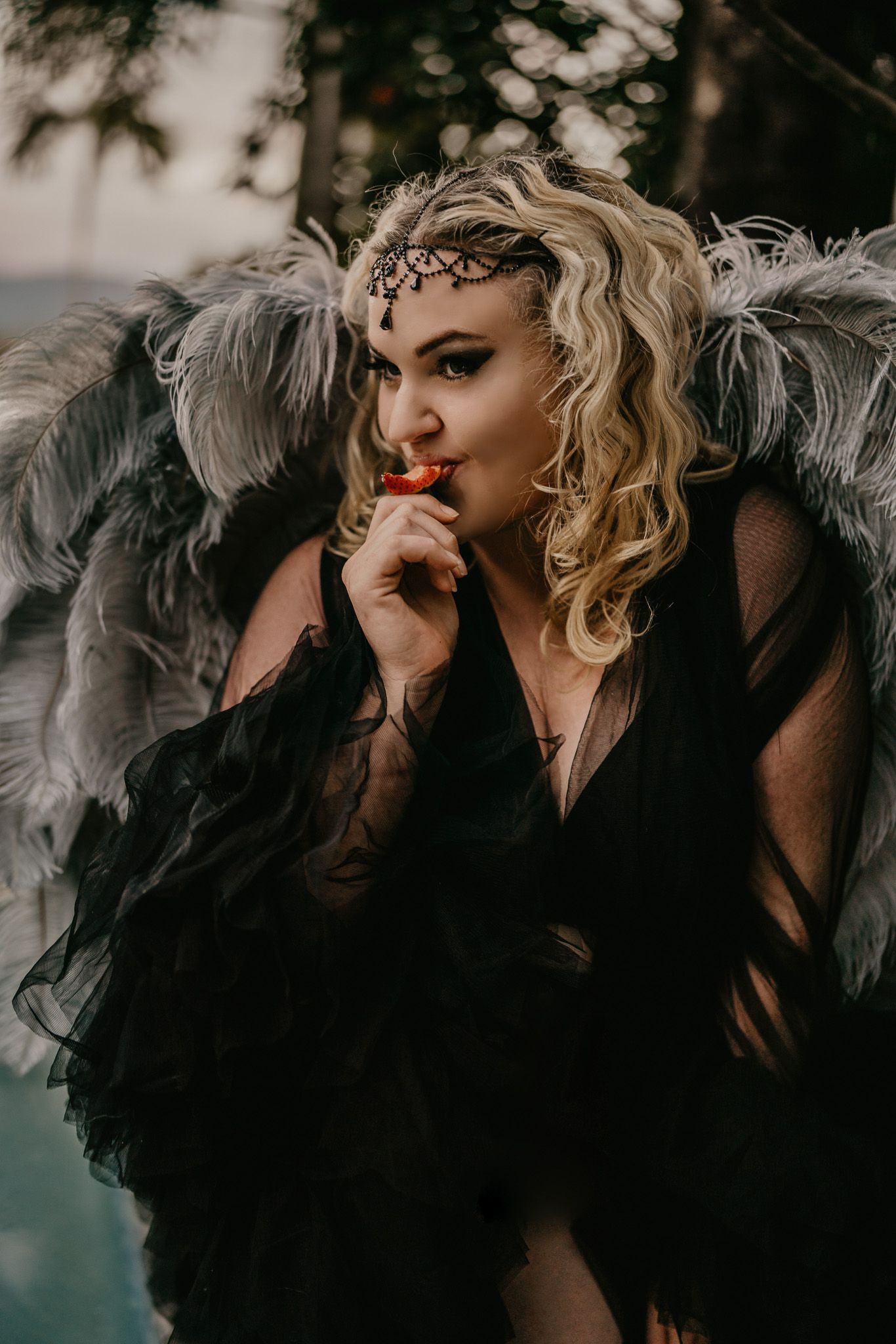 Women With Angel Wings Eating a Strawberry