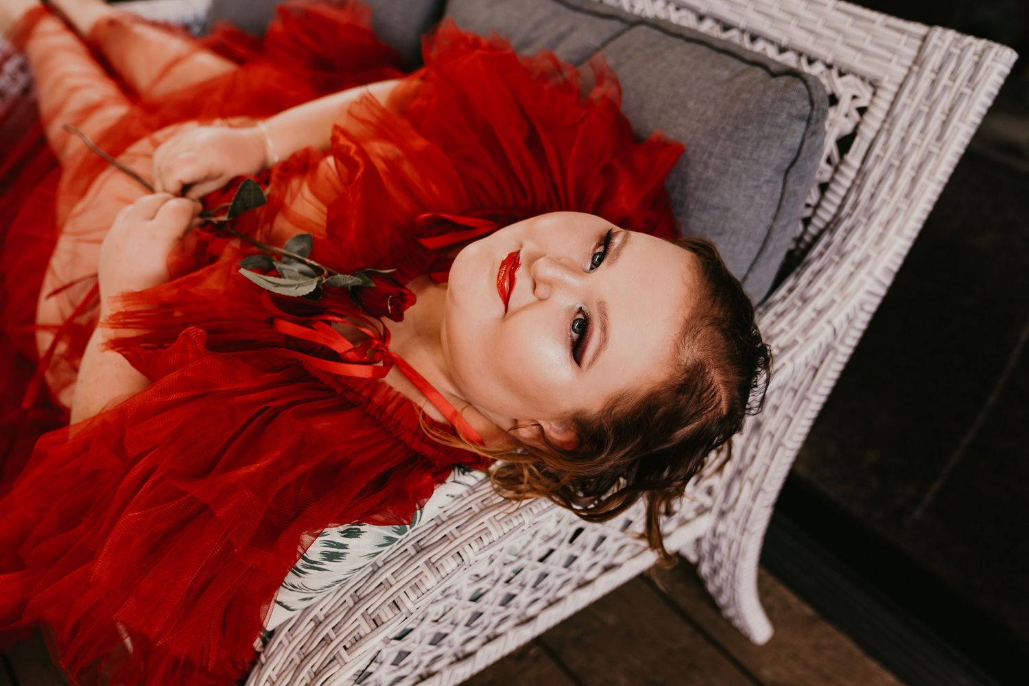 Smiling Women in Elegant Red Dress Laying Down
