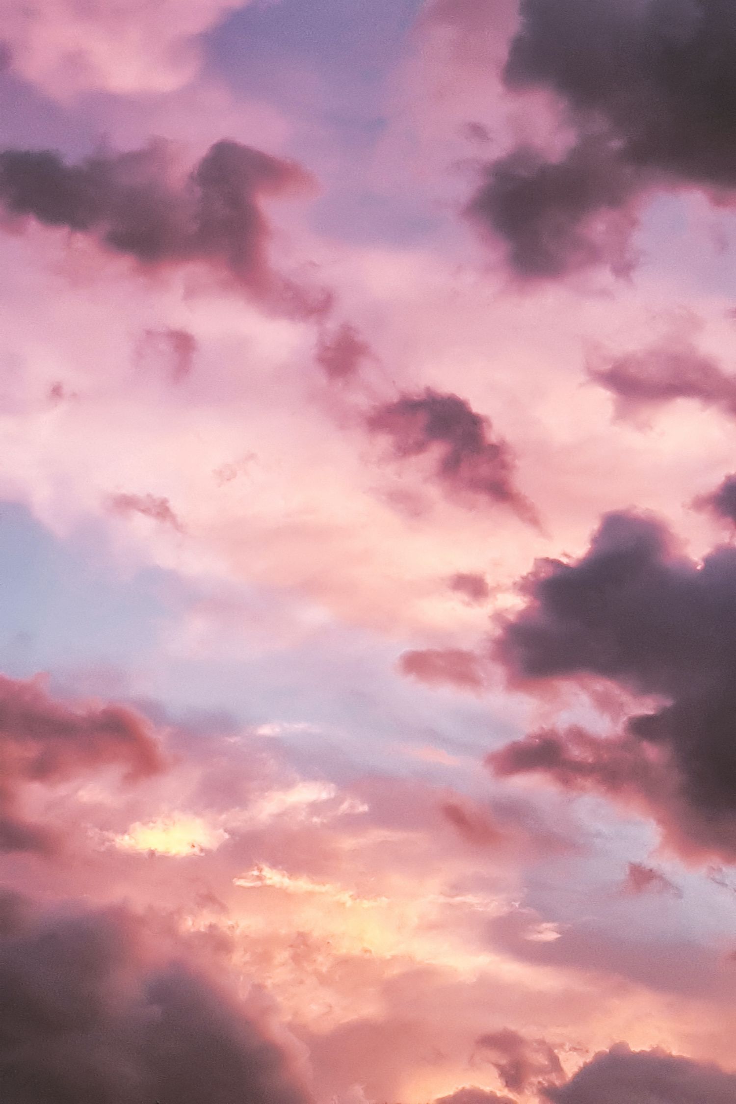 Dramatic pink and purple sunset sky with swirling dark clouds creating a mystical atmosphere.