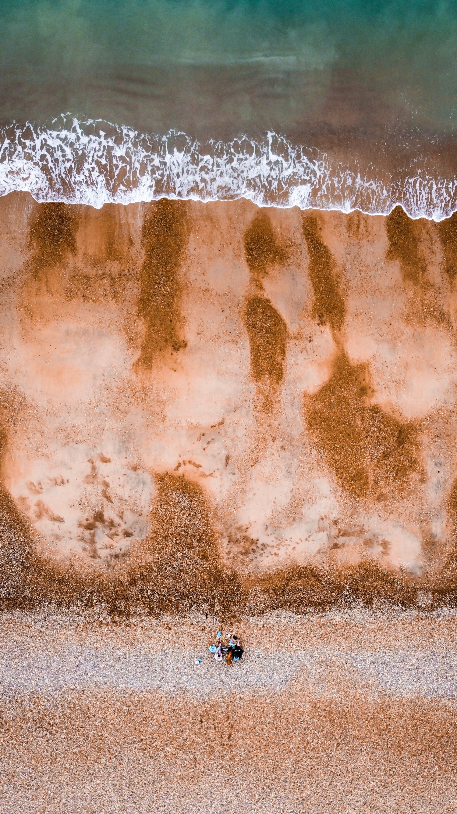 drone photo of the surf hitting the beach