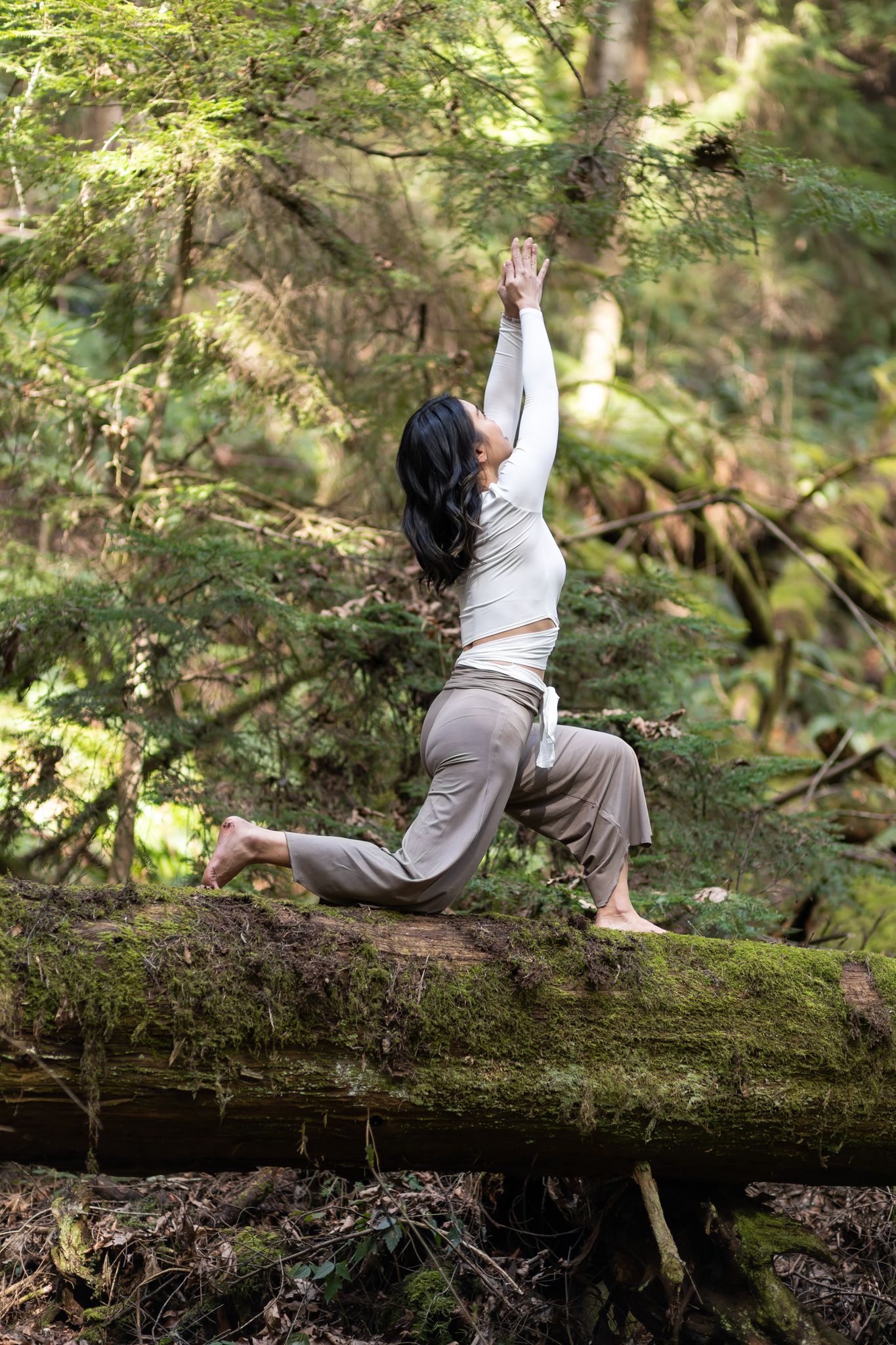 yoga instructor personal branding photos in Kirkland, WA woman in woods on fallen tree doing yoga pose low lunge hand ab