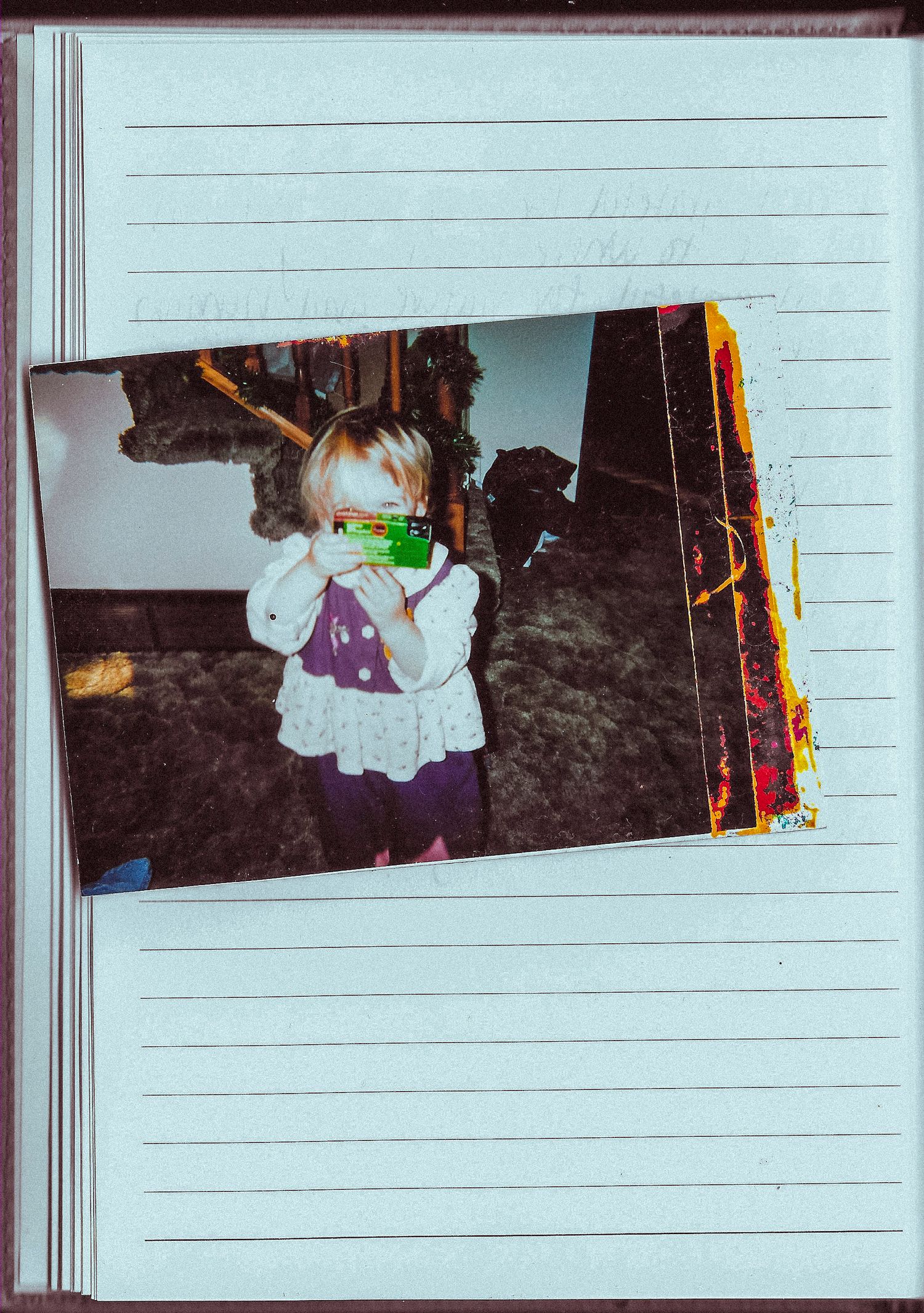 An old photograph mounted in a lined journal shows a person wearing a purple dress.