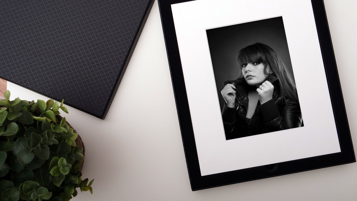 Styled detail of an opened diamond folio presentation box with fine art prints and a light sheen finish.