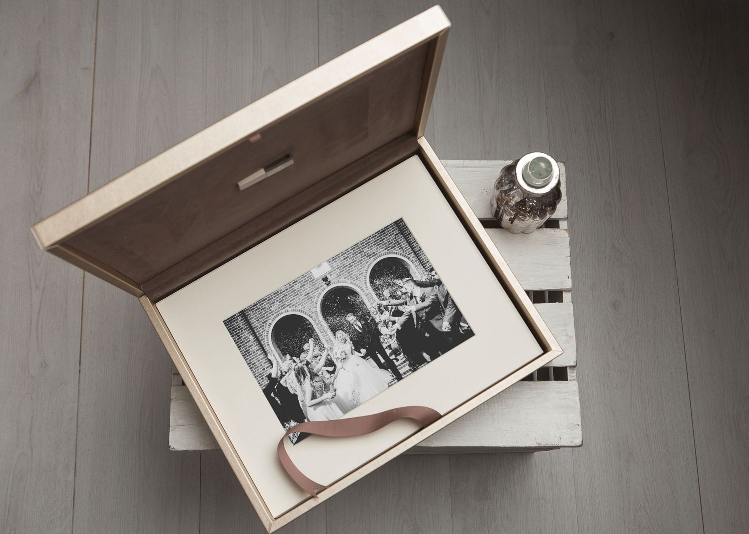 Styled detail of an opened ultimate presentation box with fine art prints and finished in metallic champagne.