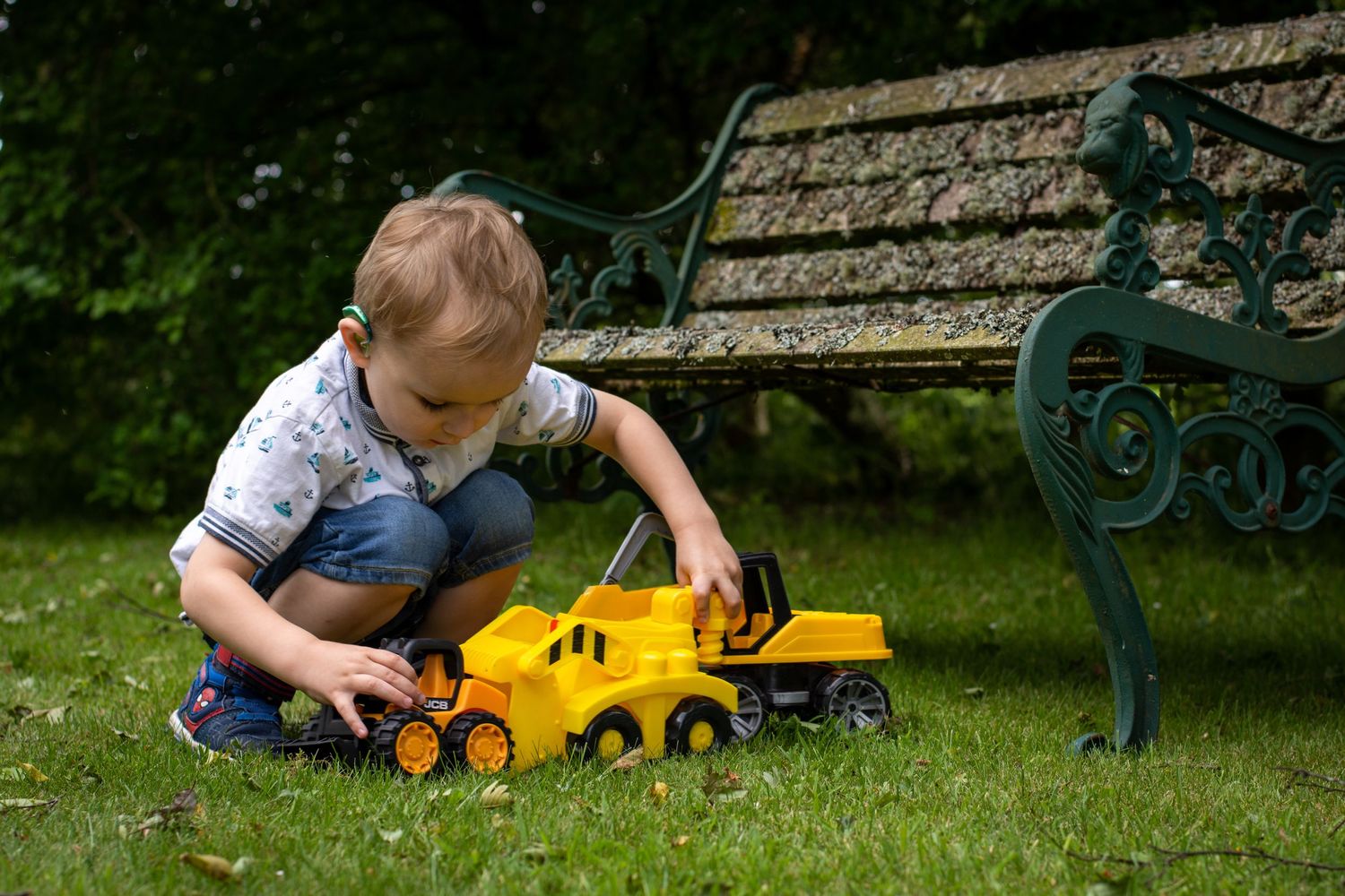 Candid portrait of Tony's son playing with his toy trucks in the garden at Aberdeen, Scotland.