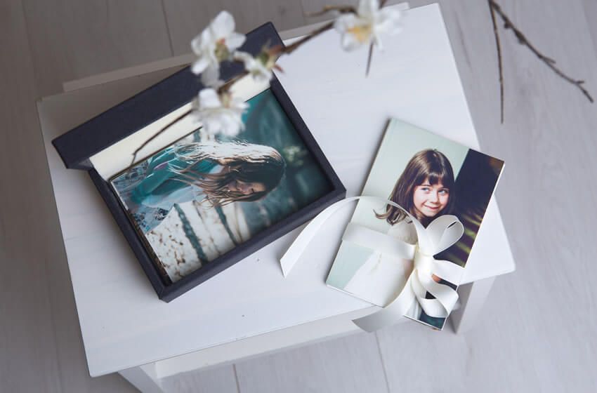 Professional photo prints and packaging materials displayed on a white surface.