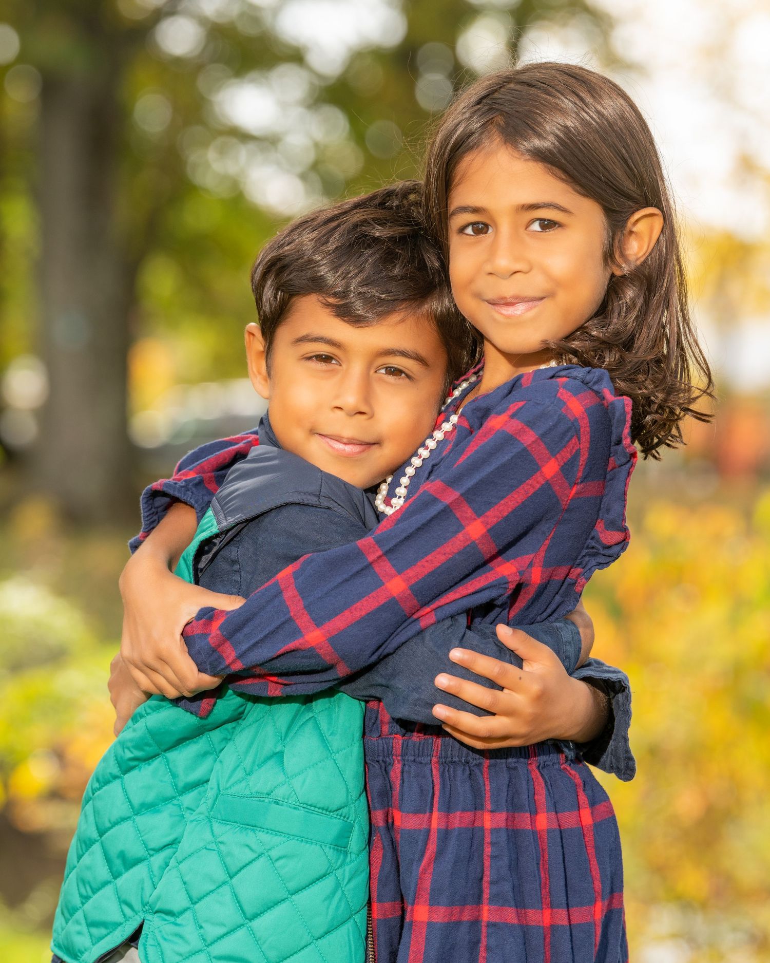 Warm family embrace captured in a series of close-up shots against fall colors.