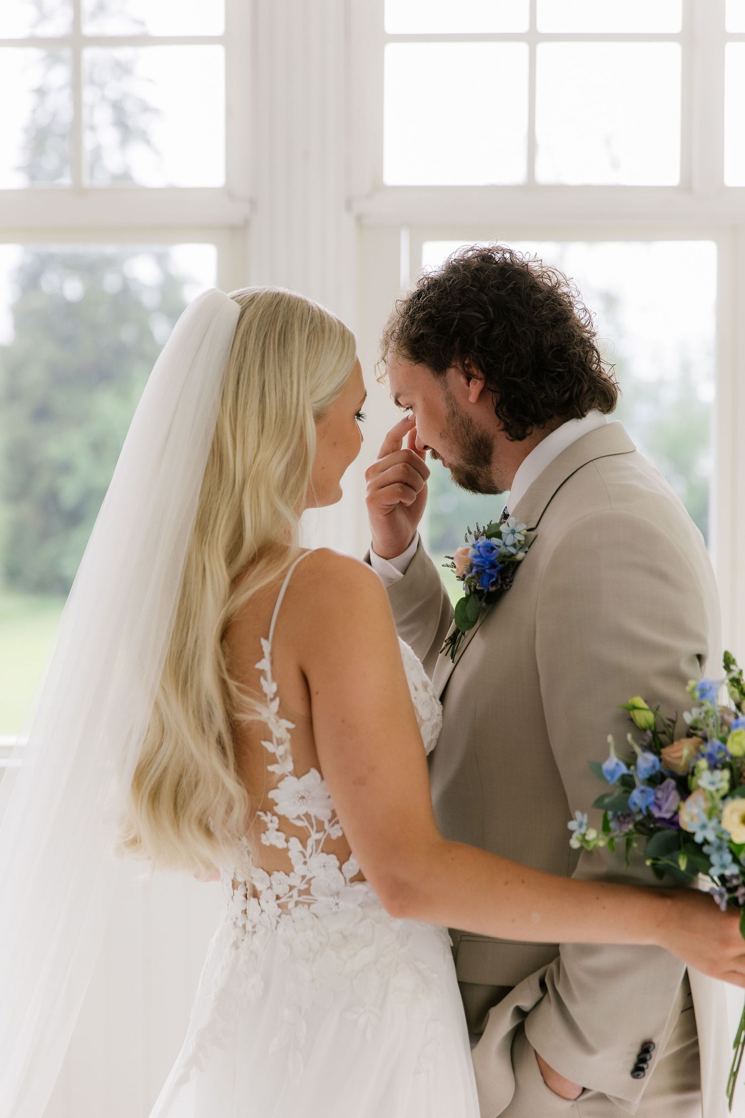 Sulhanen ja morsian yhdessä first look kohtaamisen jälkeen hääpäivänä