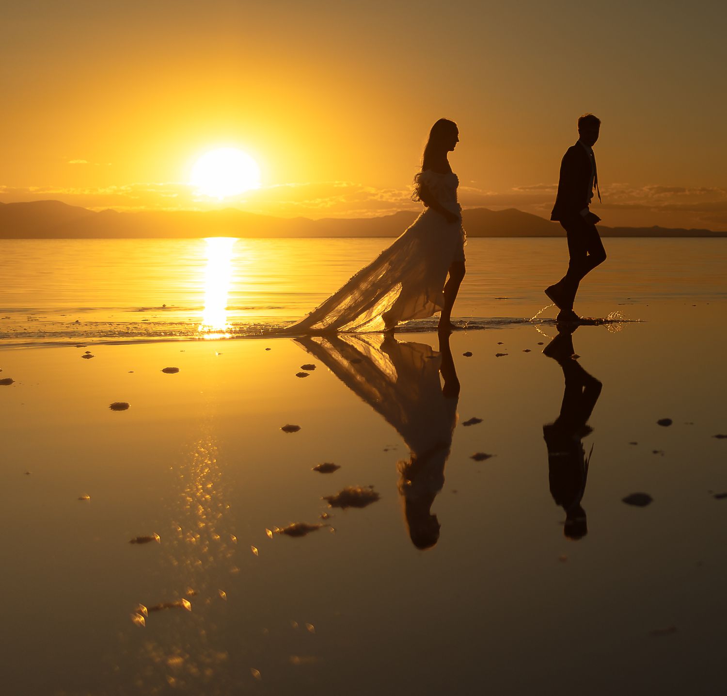 a bride and groom in their wedding attire at the Pink Lake in Utah at sunset
