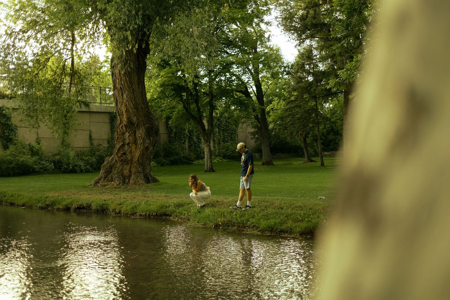 A couple at their engagement session exploring the park by a creek
