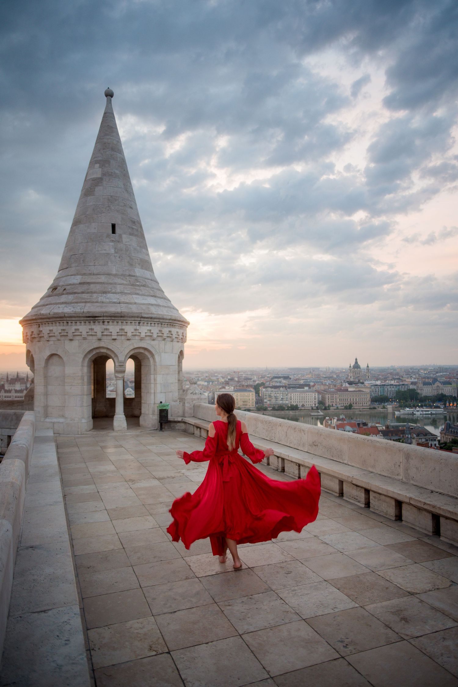 Girl in red dress exploring fisherman's bastion during sunrise in Budapest, Hungary