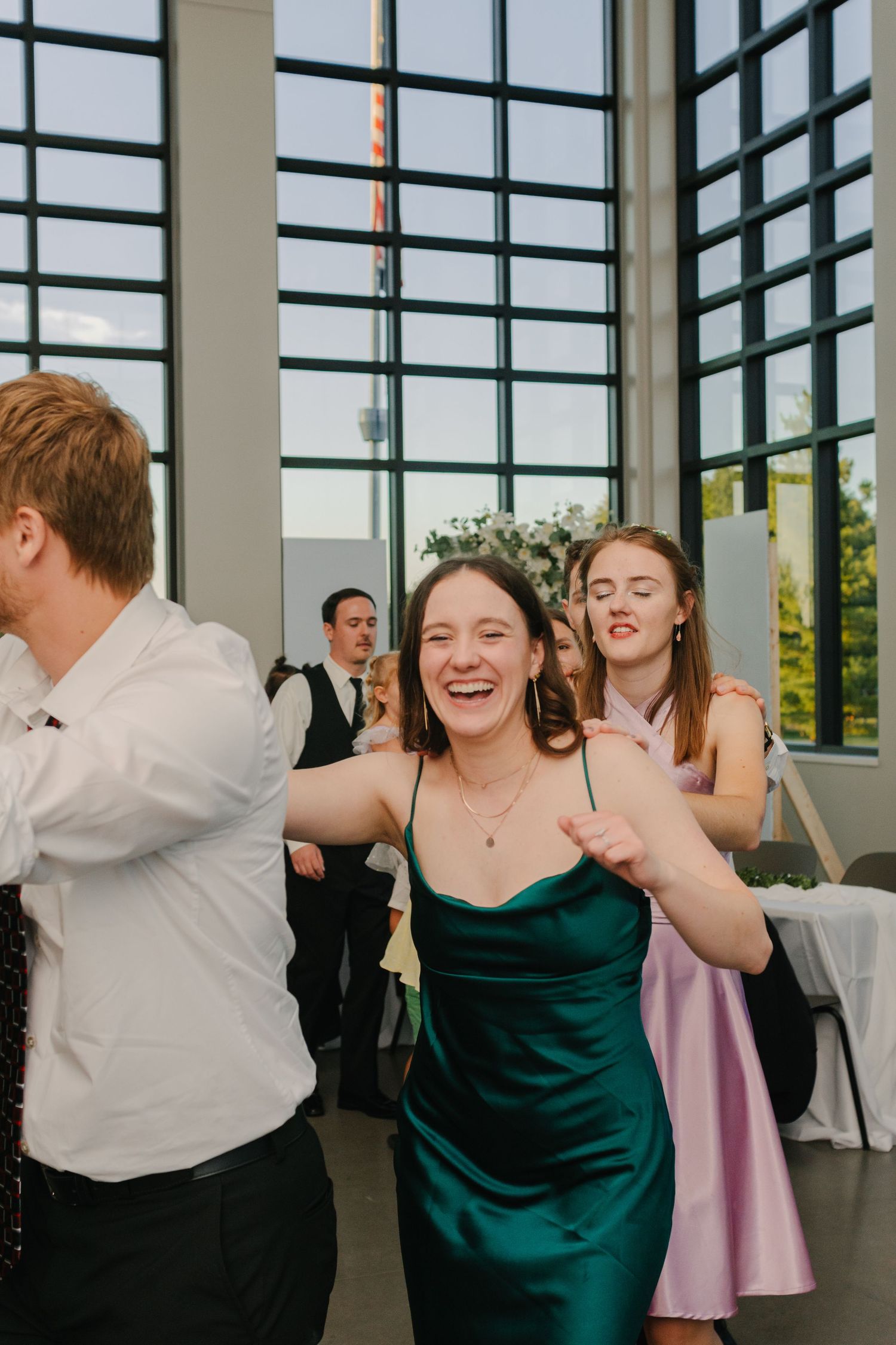 Joyful dancing at wedding reception with guests in formal attire.