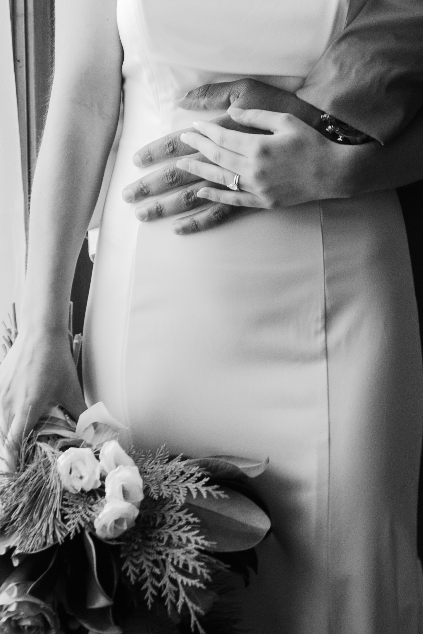 Close-up of white wedding dress details with floral and greenery accents.