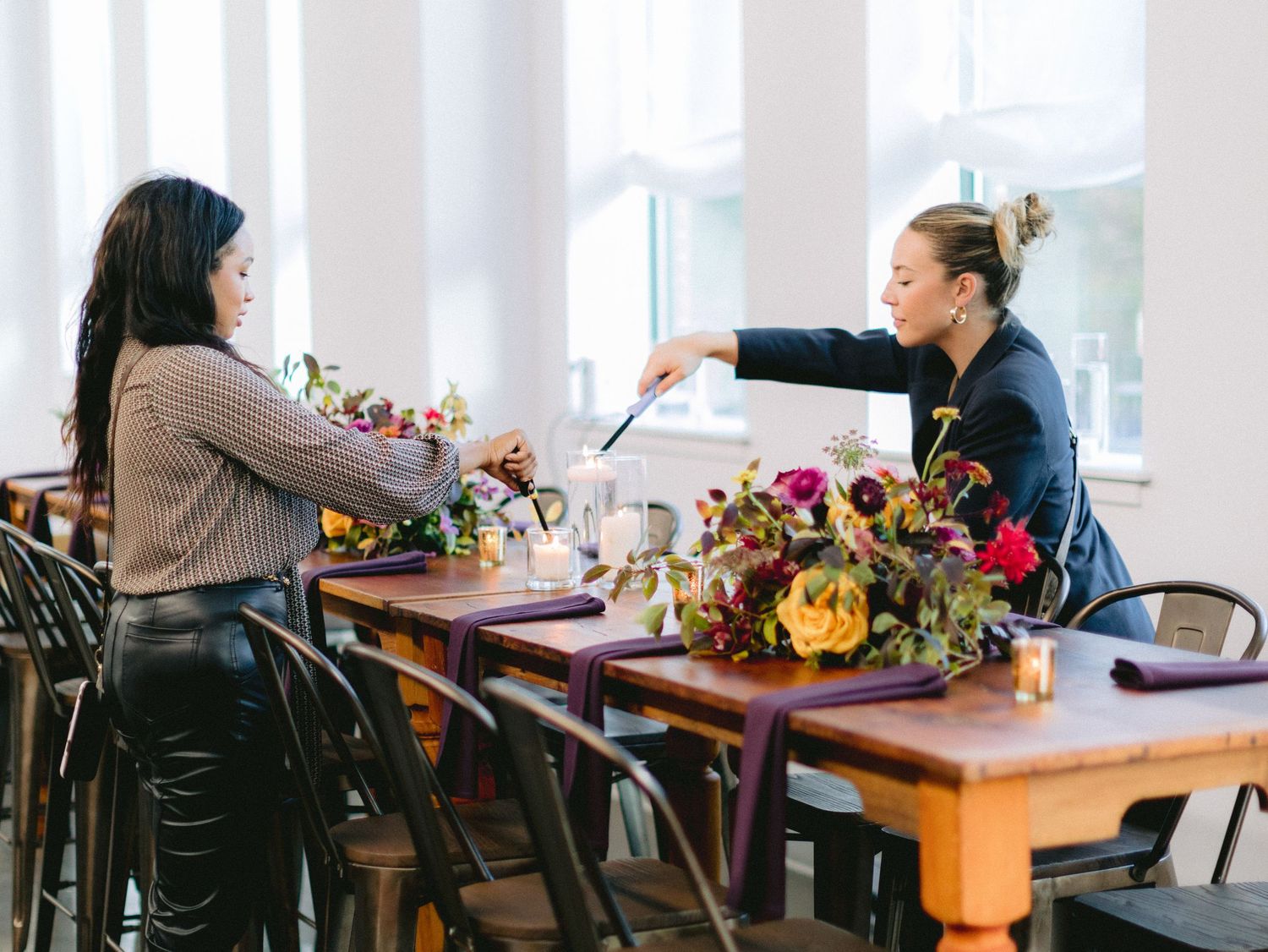 Two people discussing plans at a wooden table with colorful floral arrangements.