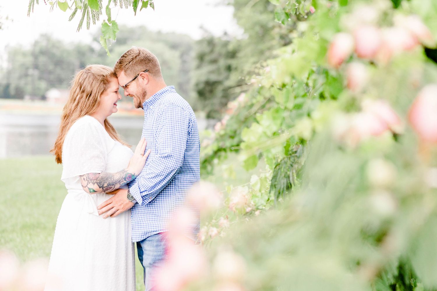 A romantic moment captured between a couple in a sunlit garden setting.