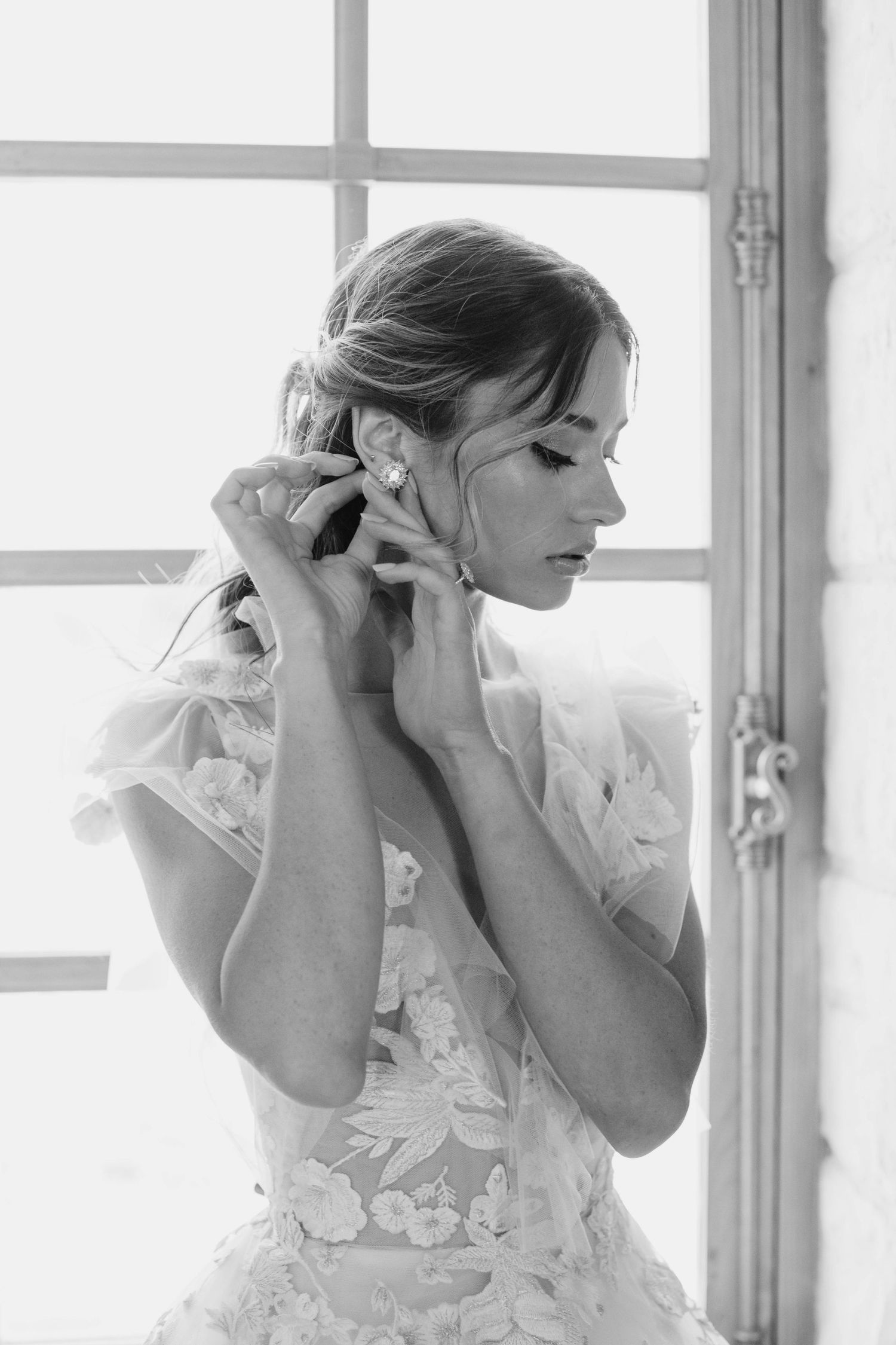 Delicate getting-ready moment by a bright window.