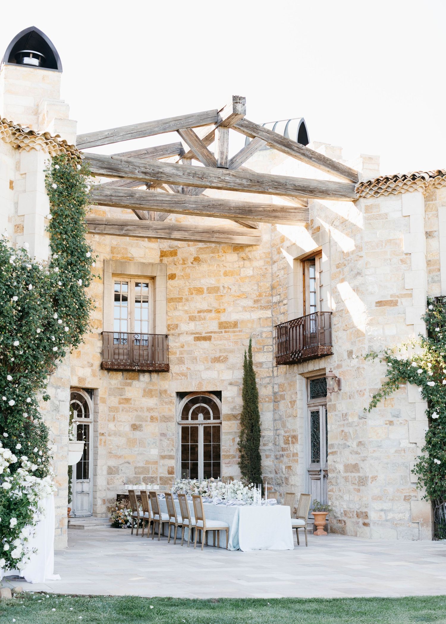 Elegant stone winery courtyard with pergola and outdoor seating area.