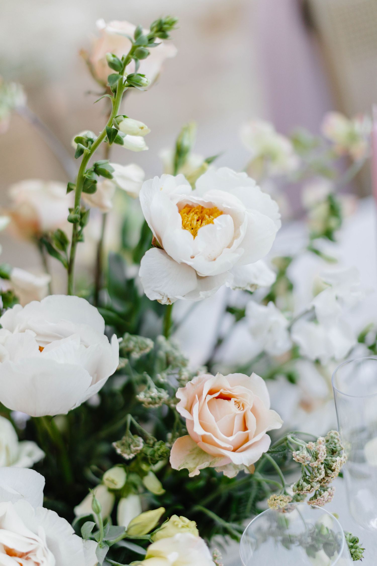 Fresh white and blush floral arrangement with delicate greenery and roses.