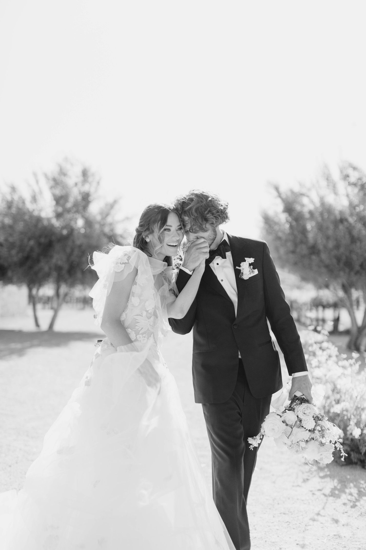 Black and white romantic wedding portrait in an outdoor vineyard setting.
