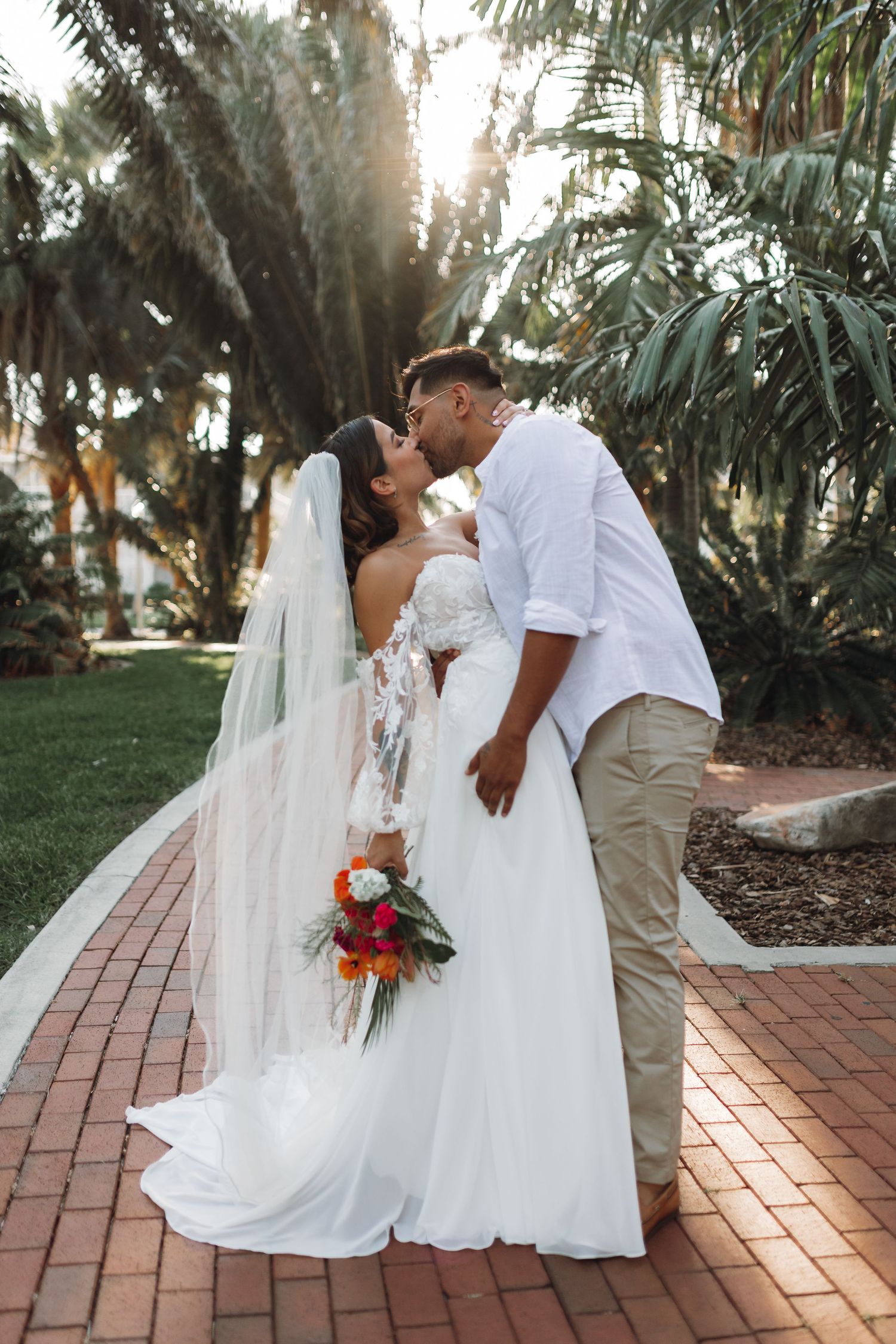 Tropical wedding bride and groom with lush palm trees and sandy beach