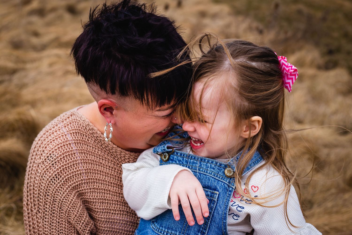 Mother and daughter laughing with faces together in Cowan Fields, Woodstock