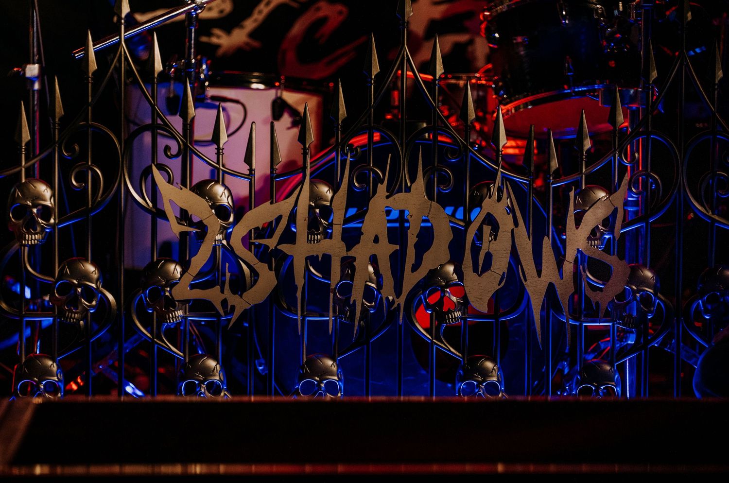 Blue illuminated band logo displayed on dark stage backdrop.