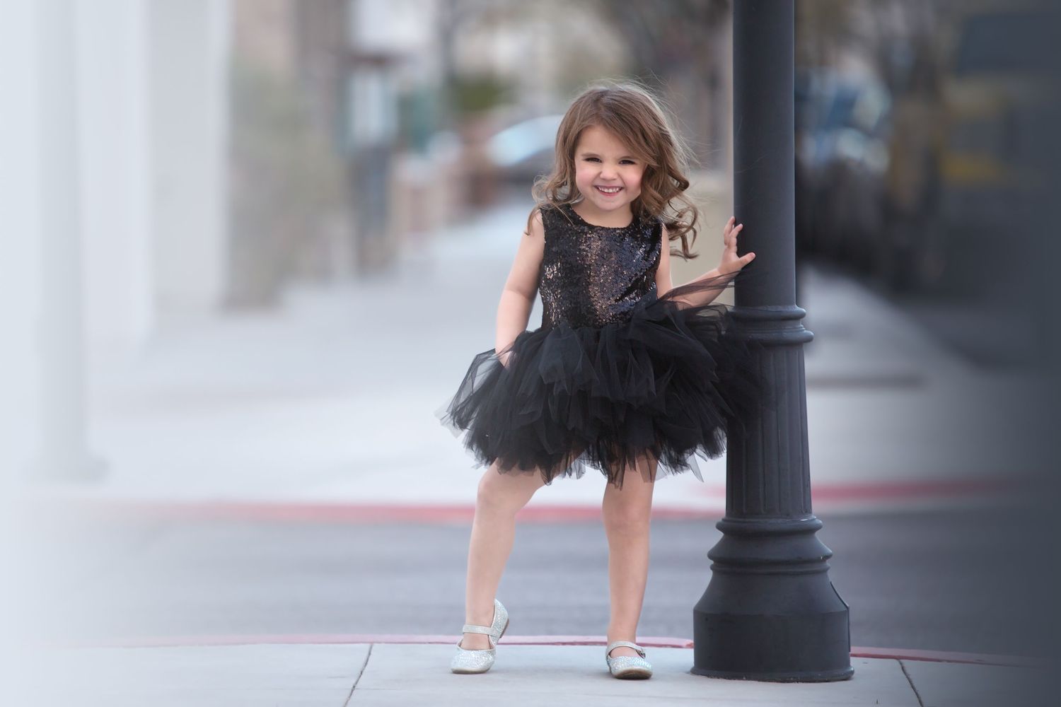 Black tutu dress photographed against urban setting with lamp post.