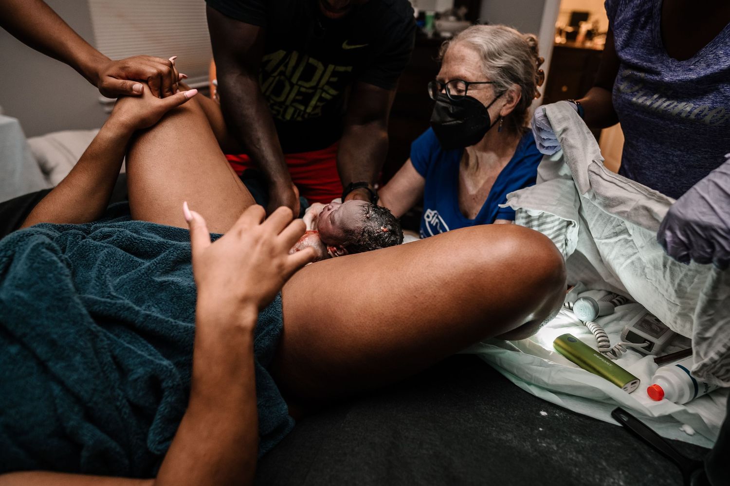 Baby Being Born Into Father's Hands With Midwife Helping