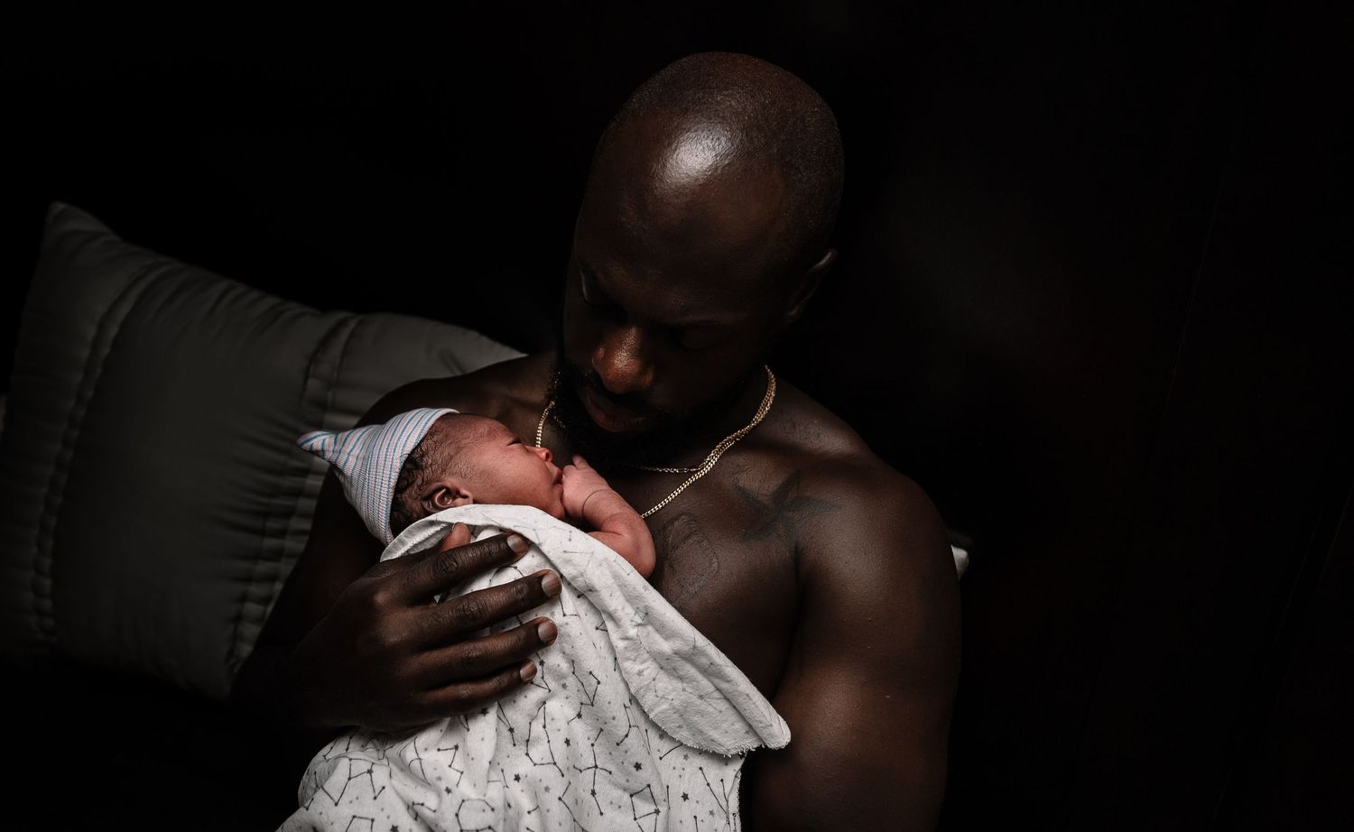 Black Father Skin To Skin With Baby In A Hat Wrapped In A Blanket
