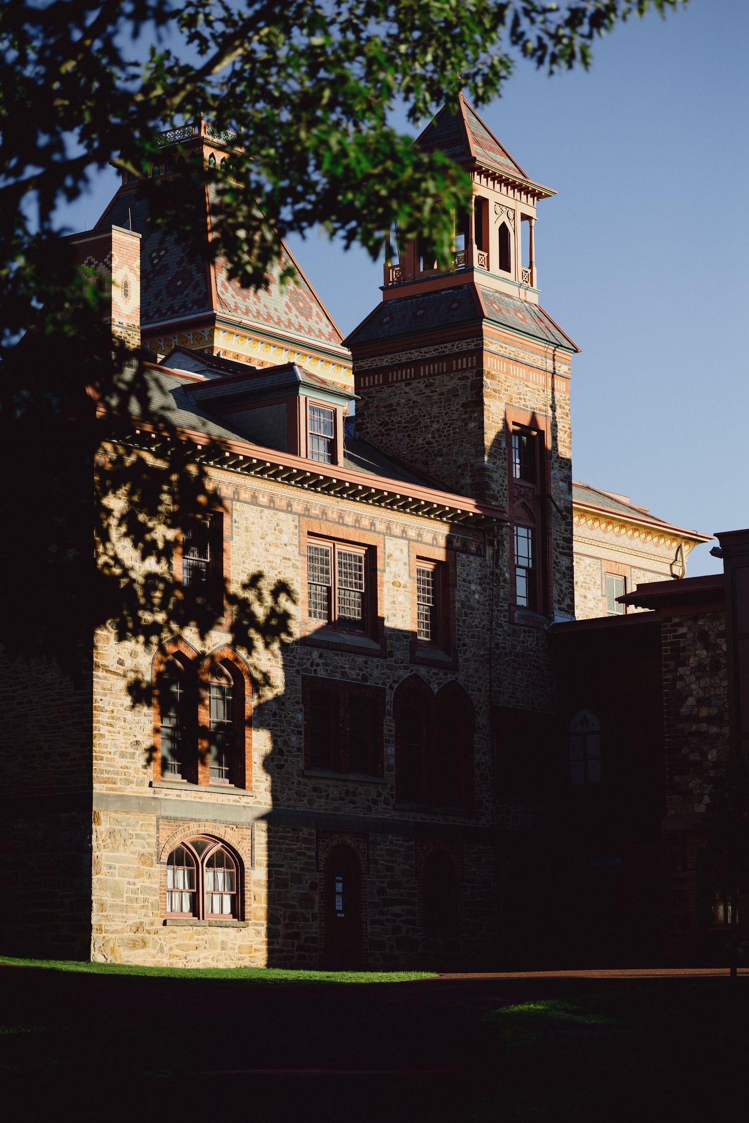 Historic brick building with ornate architecture and tower details in warm sunlight.